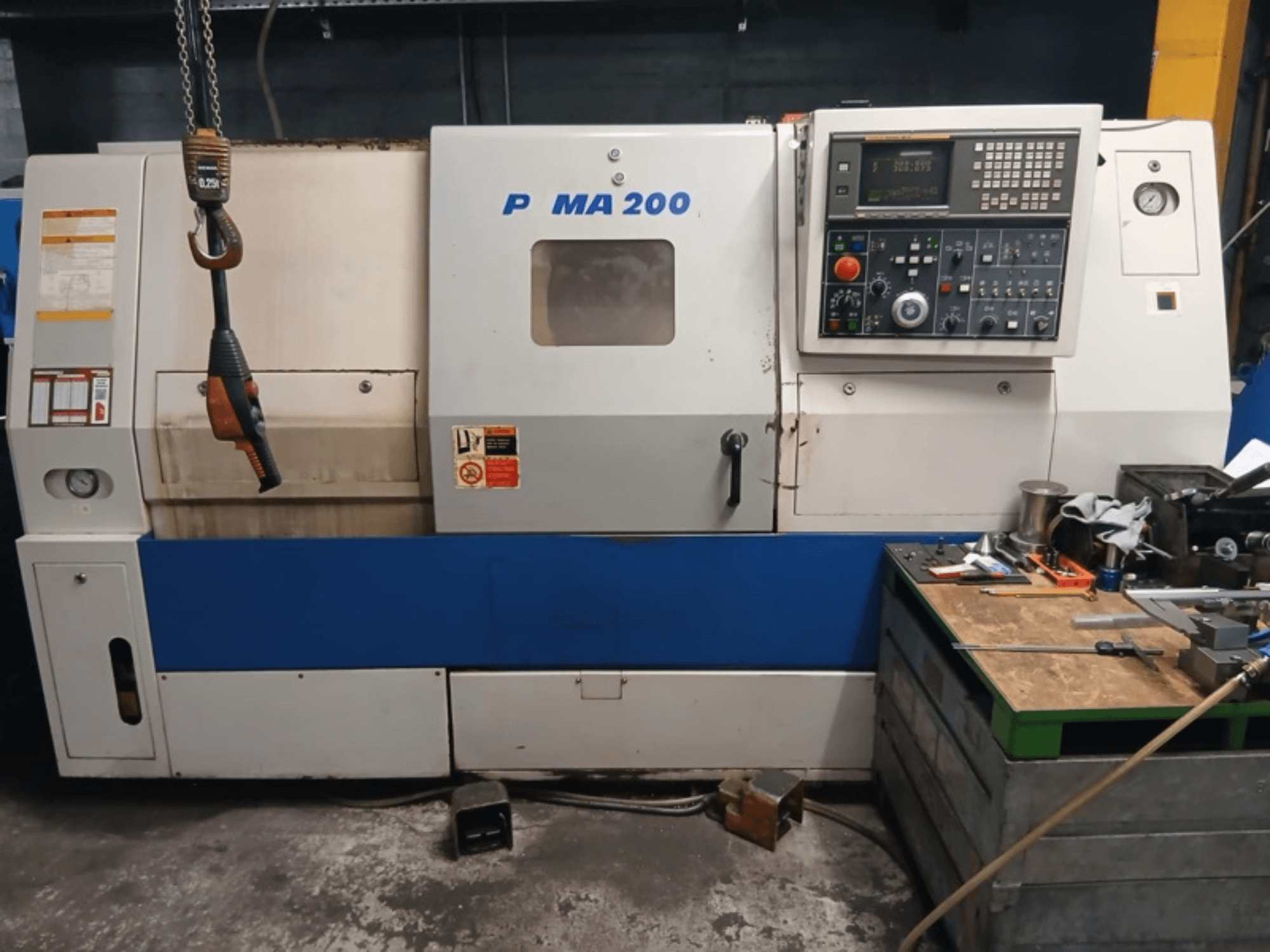 Vista frontal del torno horizontal DAEWOO EcoTurn 200, en la que se aprecian el panel de control y las etiquetas de seguridad.