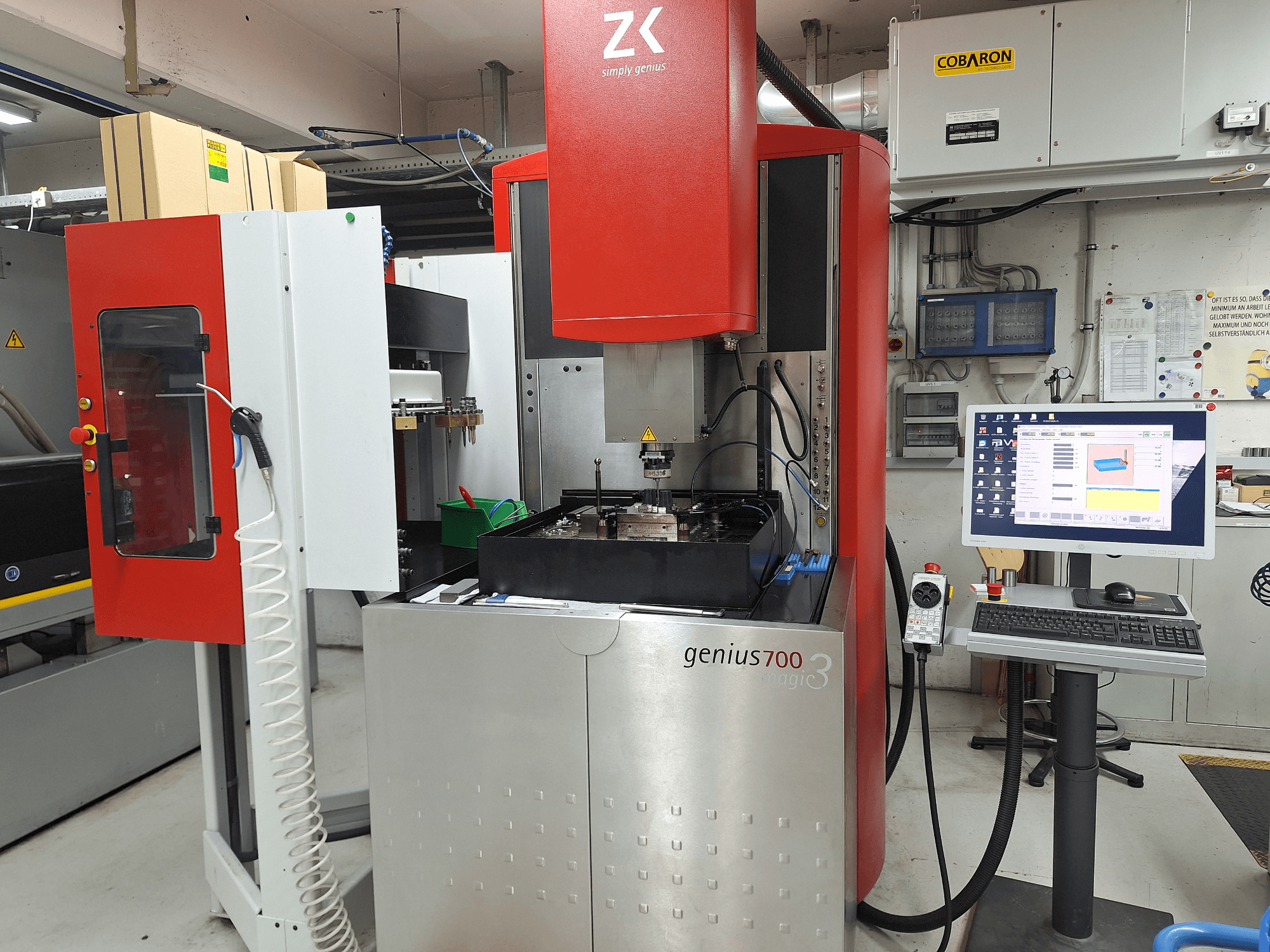 Fresadora Genius 700 de ZK, vista frontal, con panel de control de pantalla táctil y zona de mecanizado con herramientas y materiales.