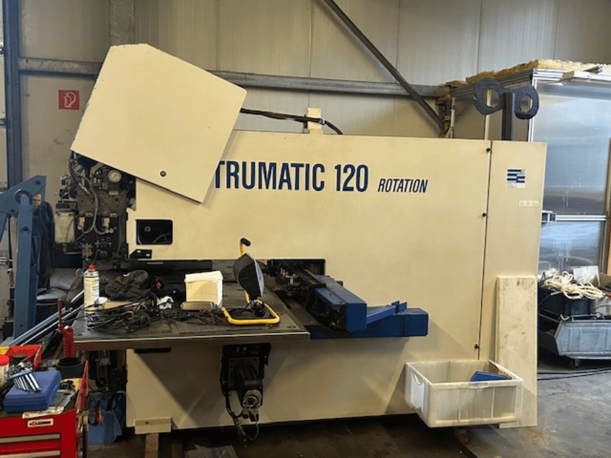 Punzonadora CNC TRUMPF Trumatic 120R en un taller, vista frontal mostrando el panel de control y las herramientas sobre la mesa.