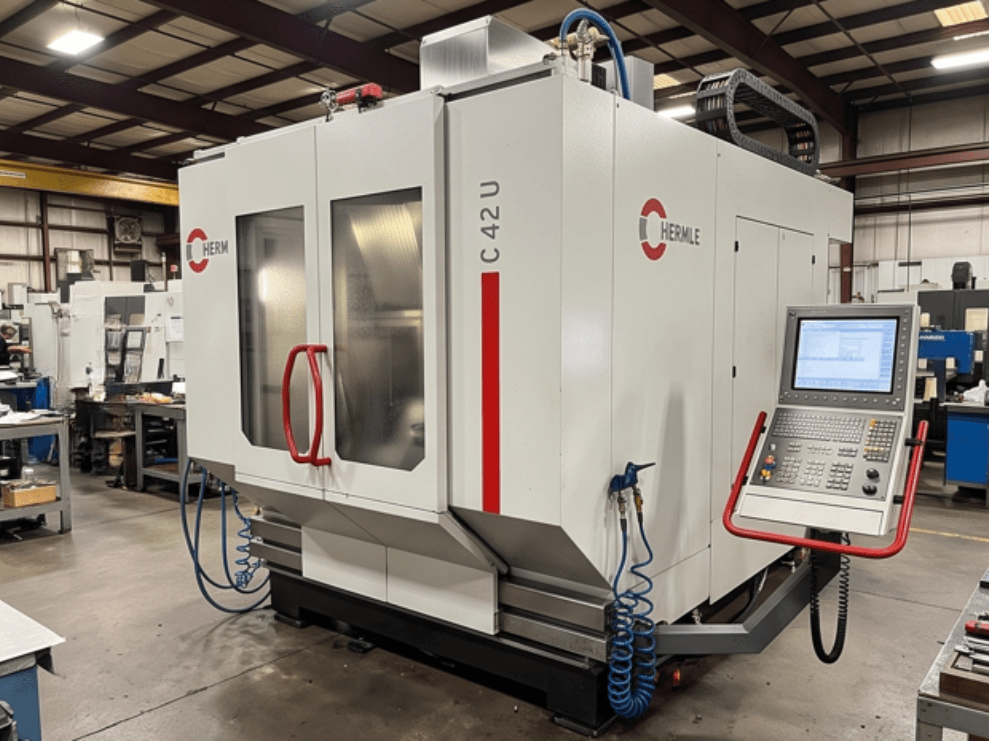 Centro de mecanizado universal HERMLE C42 en un taller; vista frontal en la que se aprecian el panel de control y los detalles de la máquina.