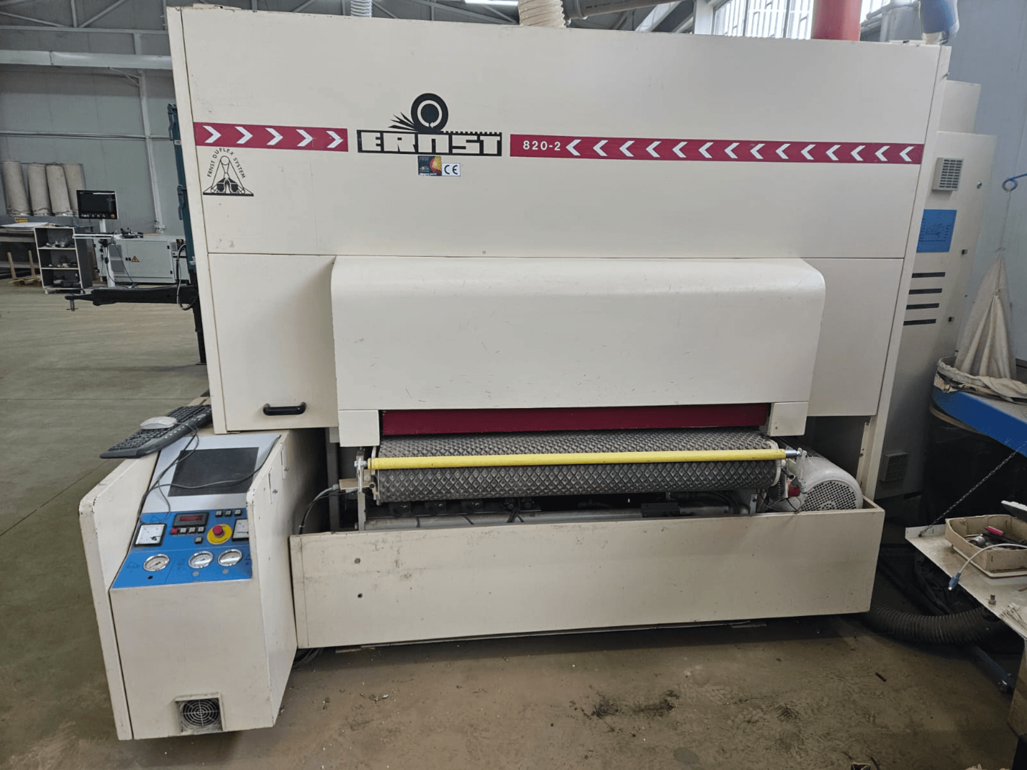 Máquina Ernst 820-2 para el tratamiento de la madera, vista frontal, con panel de control y rodillo amarillo en la alimentación.