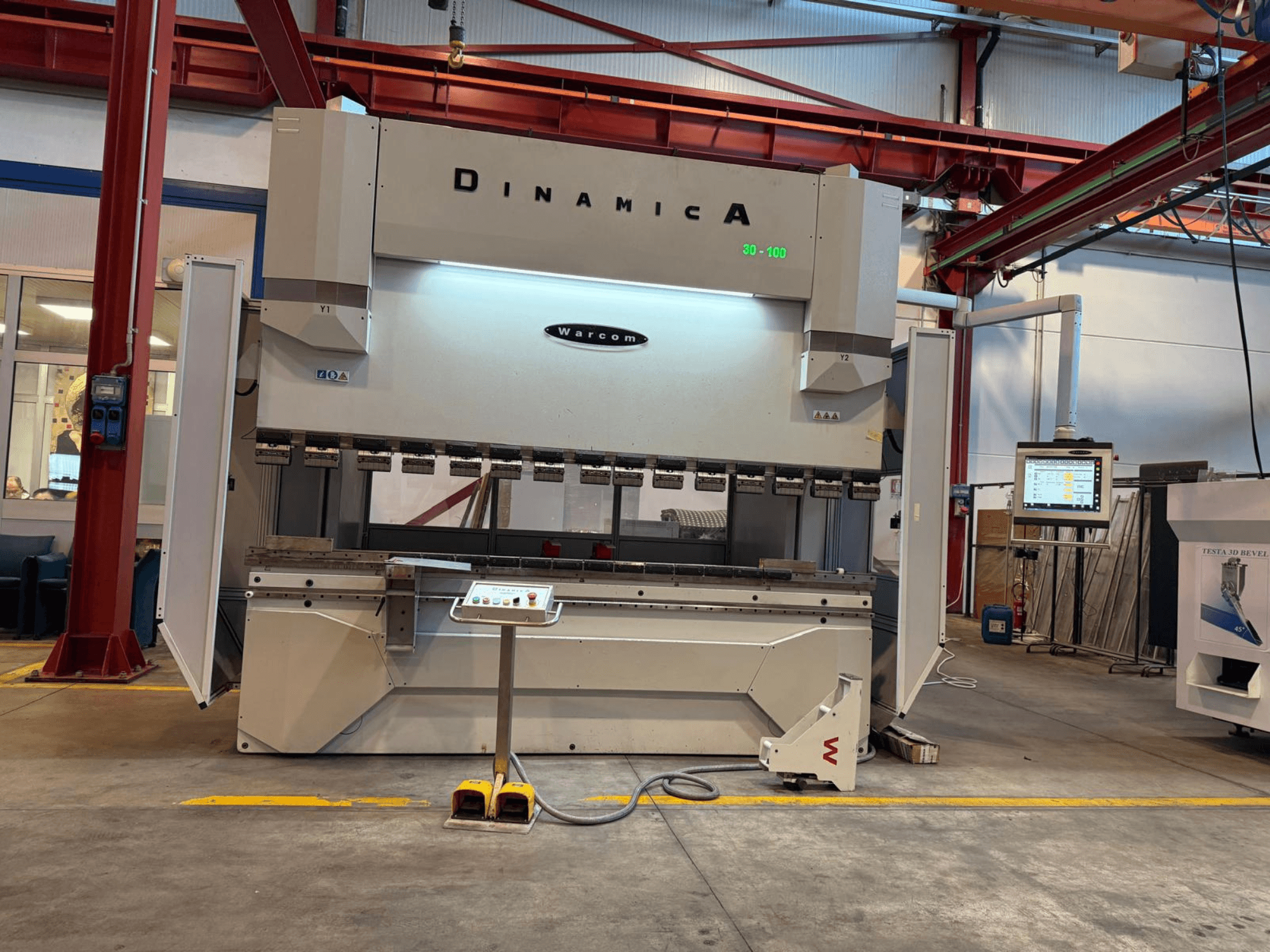 Prensa plegadora hidráulica Dinamica Warcom, vista frontal. Dispone de panel de control y múltiples estaciones de herramientas para plegado de precisión.