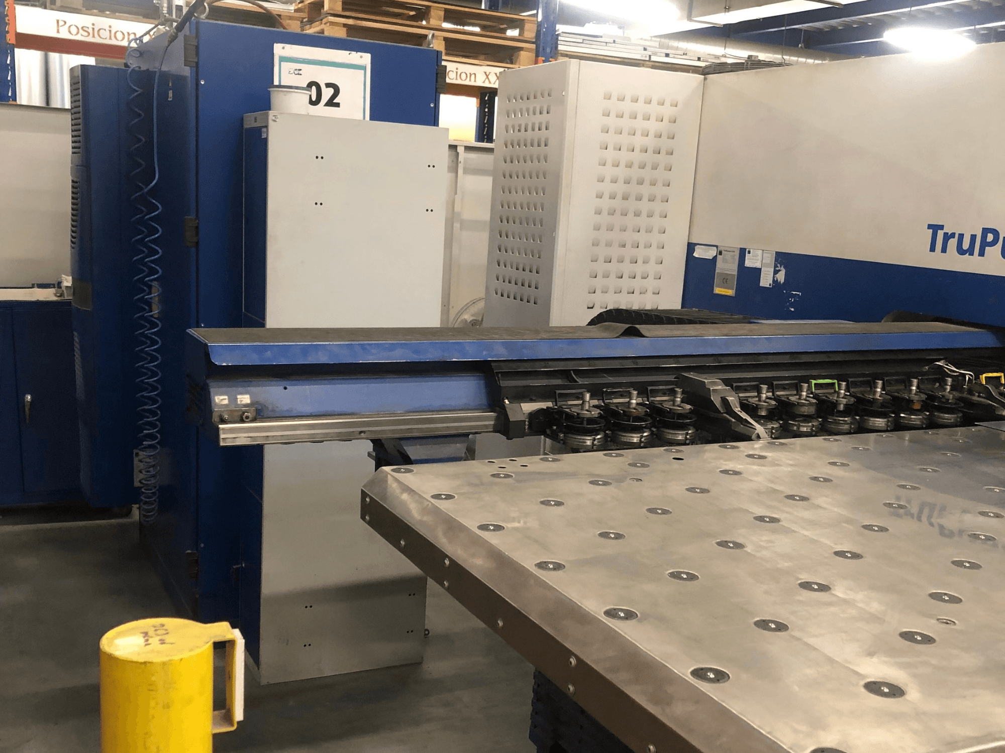 Máquina punzonadora CNC TRUMPF TruPunch 5000, vista frontal en la que se aprecian la torreta portaherramientas y el panel de control, con una mesa de trabajo metálica junto a ella.