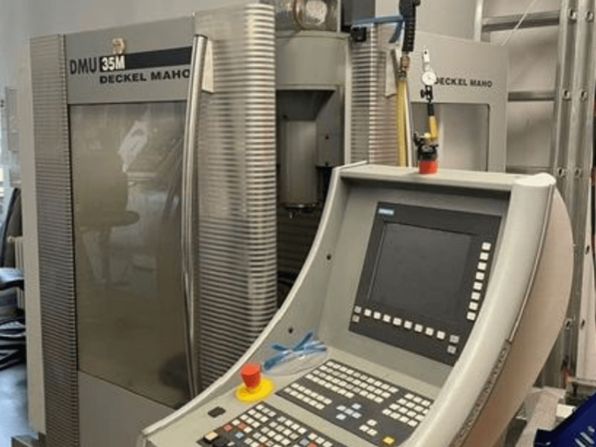 Vista frontal del centro de mecanizado universal DECKEL MAHO DMU 35M, en la que se aprecian el panel de control y los detalles de la máquina.