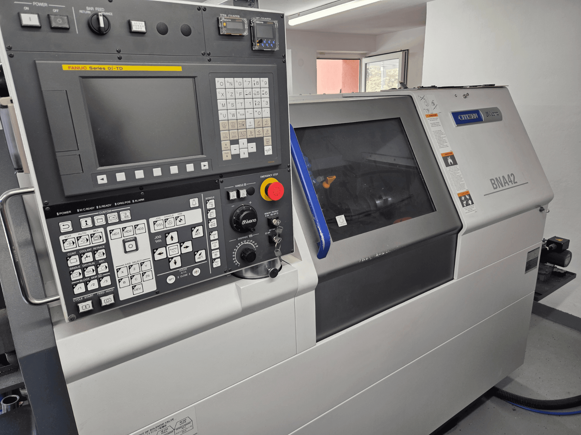 Torno horizontal Miyano BNA42S2, vista frontal en la que se aprecia el panel de control con la interfaz y la pantalla FANUC de la serie Oi-TD.