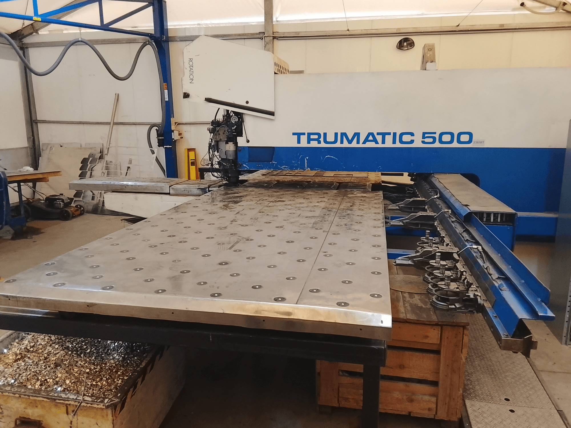 Máquina CNC Trumatic 500, vista superior, con una gran mesa de corte de metal con herramientas montadas y virutas debajo.