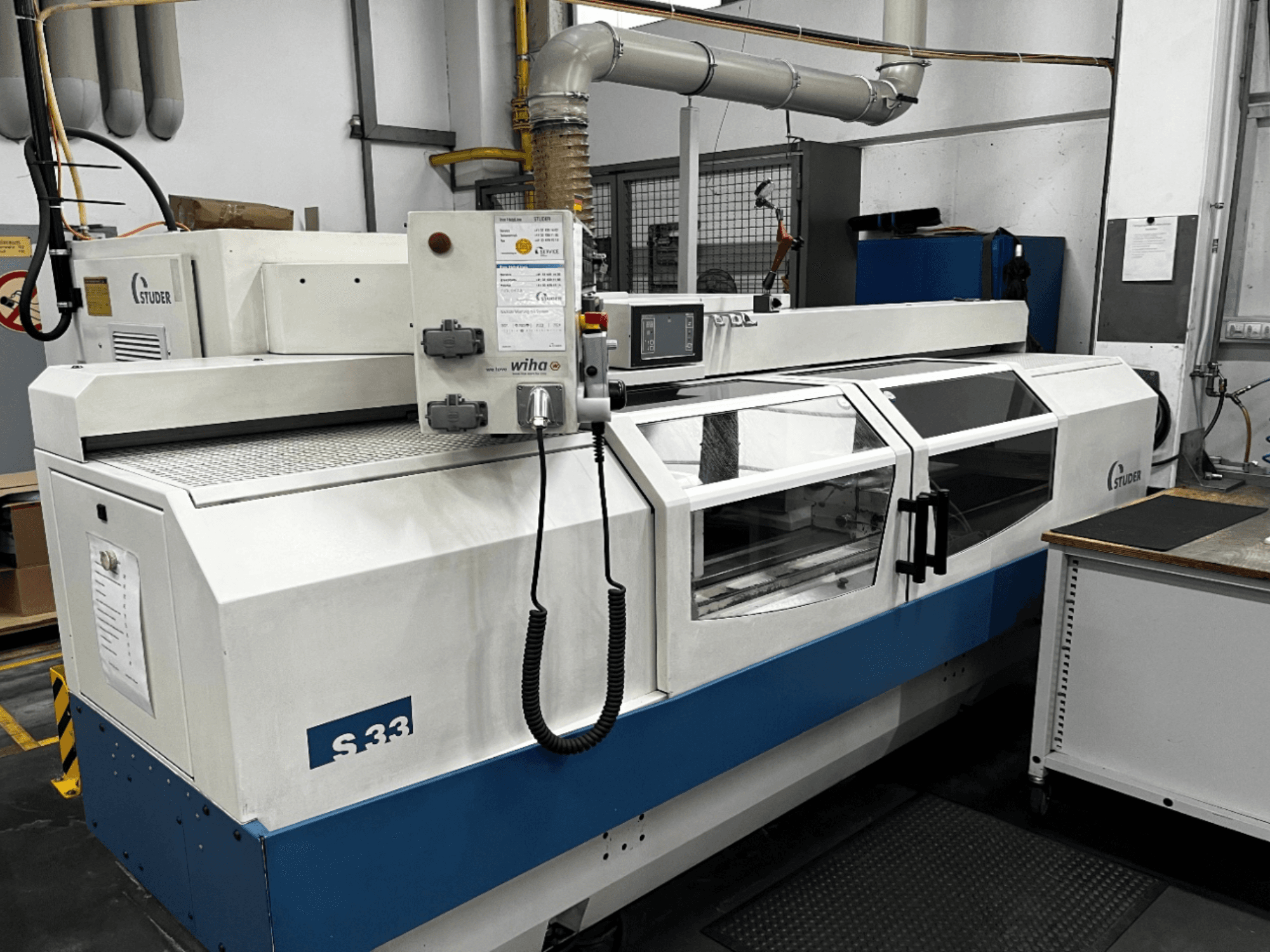Rectificadora cilíndrica CNC STUDER S33, vista frontal; dispone de panel de control y puertas de seguridad de cristal. Entorno industrial.