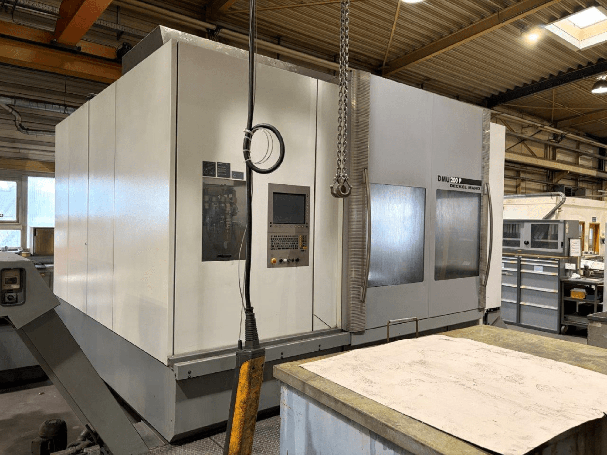 Centro de mecanizado universal DMG MORI DMU 200 en un taller, vista frontal, mostrando su panel de control y características exteriores.