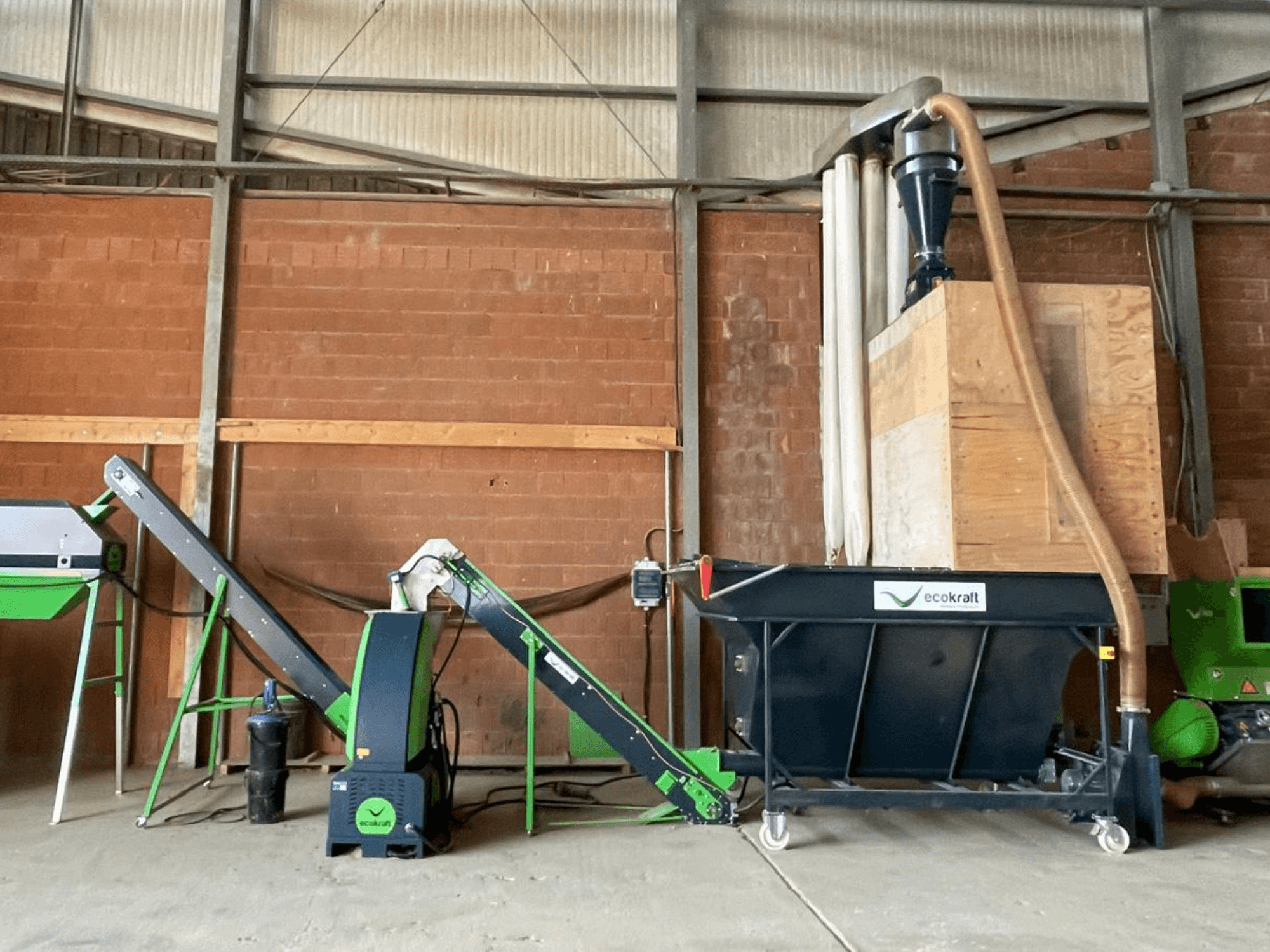 Máquina herramienta ECOKRAFT LP 22 en un almacén, equipada con una cinta transportadora y un sistema de captación de polvo. Vista lateral en la que se destacan los componentes funcionales.