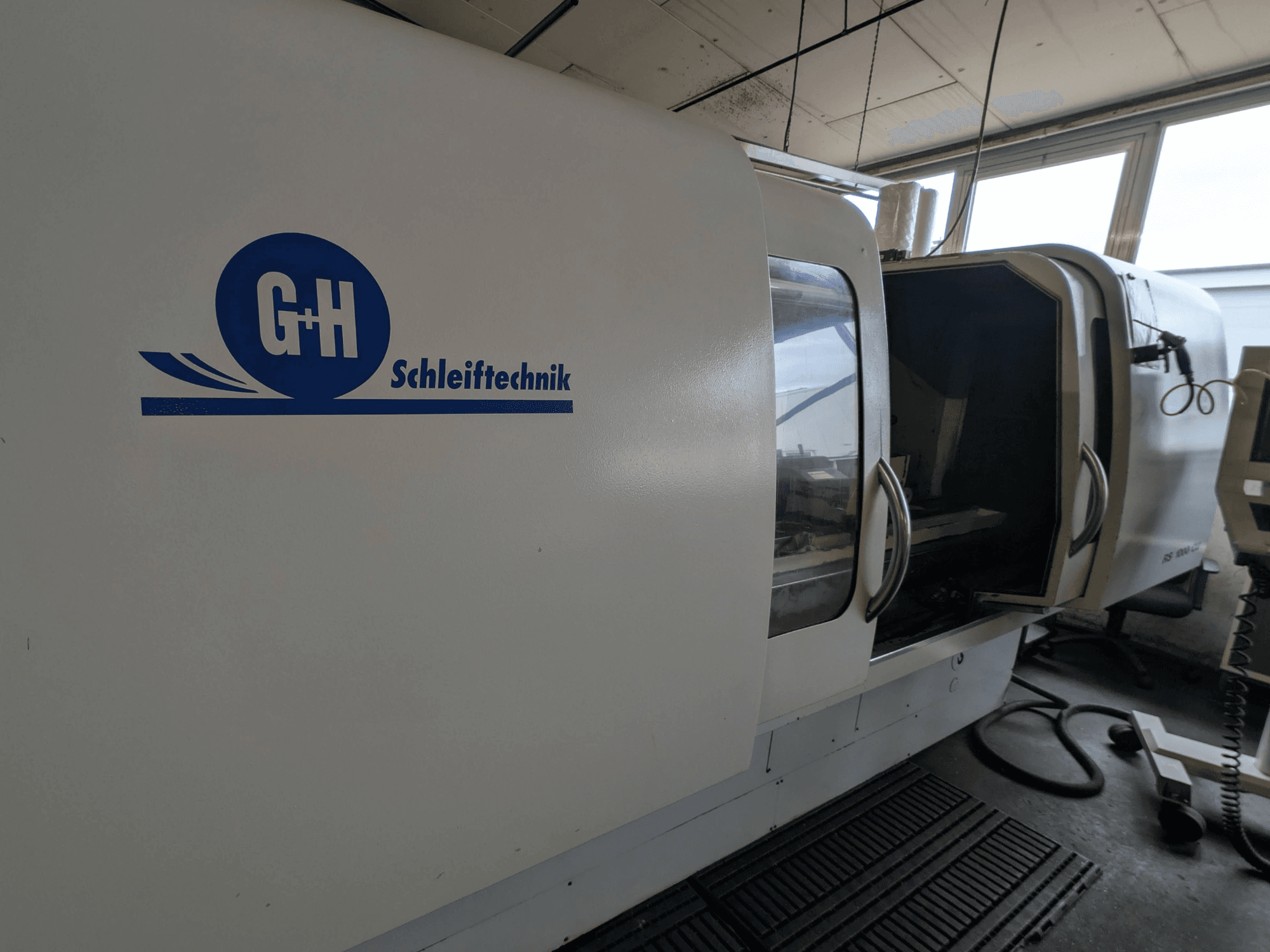 Rectificadora cilíndrica GEIBEL & HOTZ RS 1000 CU, vista lateral mostrando el panel de control y la puerta de acceso abierta.