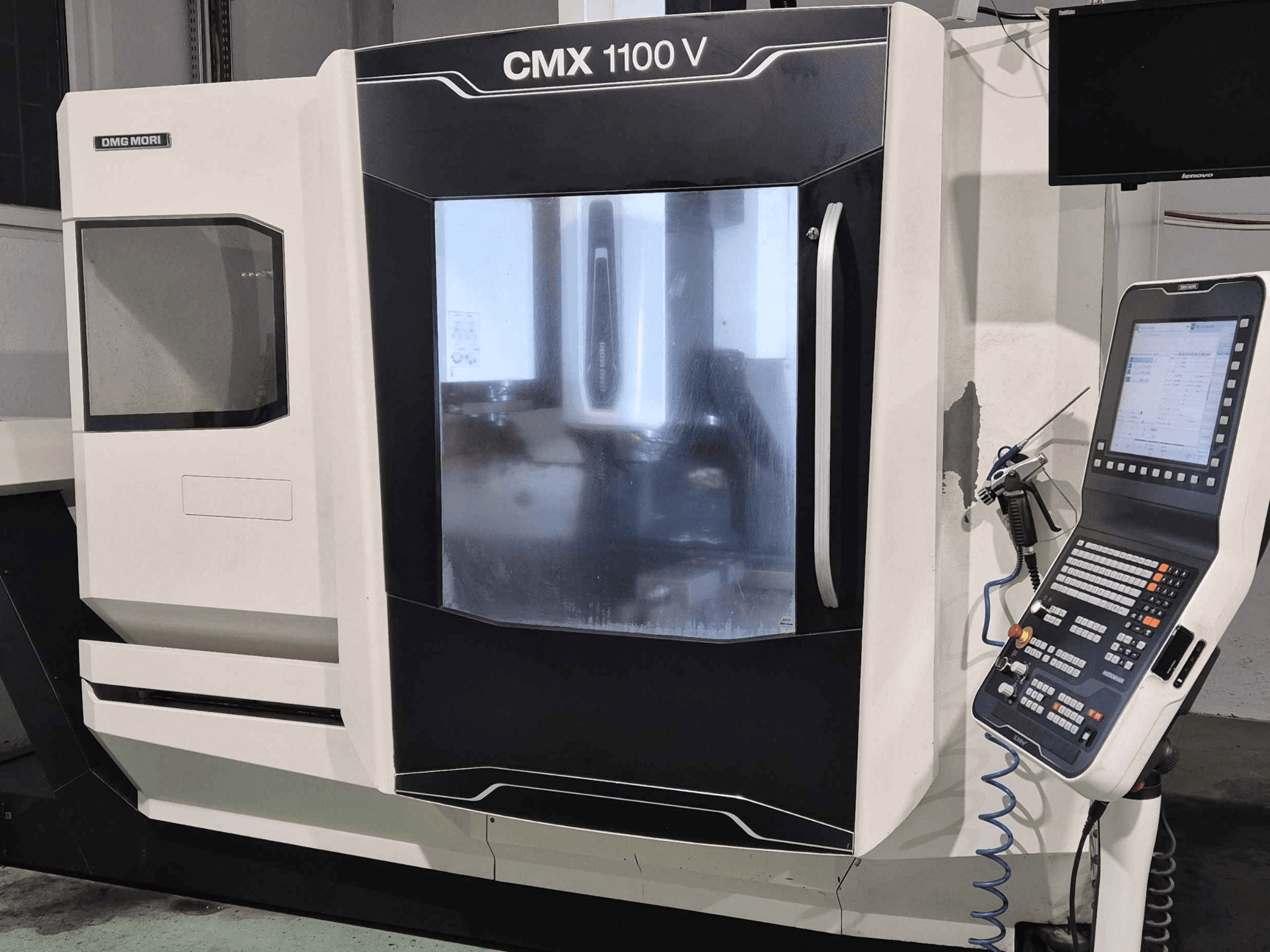 DMG Mori CMX 1100 V, vista frontal de la máquina CNC con panel de control, pantalla digital y configuración de refrigerante visibles.