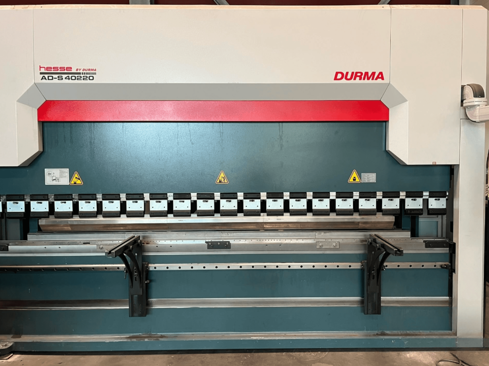 Plegadora Durma AD-S 40220 vista desde delante, con múltiples herramientas de plegado y etiquetas de seguridad.