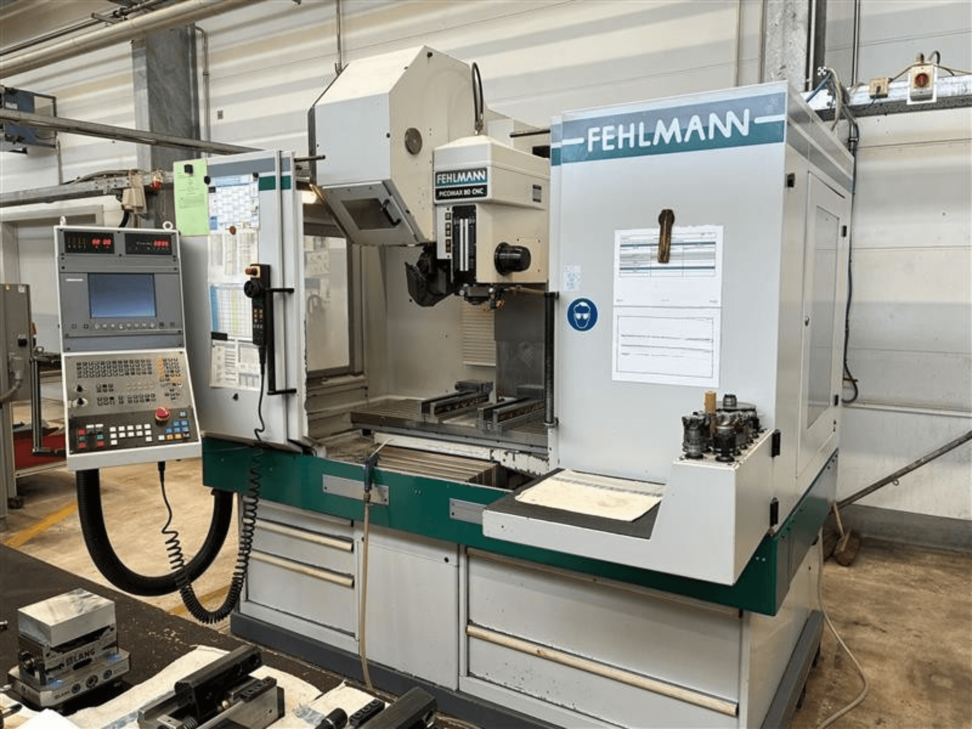 Centro de mecanizado vertical FEHLMANN PICOMAX 80 CNC-W 2/3 visto desde delante, en el que se aprecian el panel de control y el espacio de trabajo.