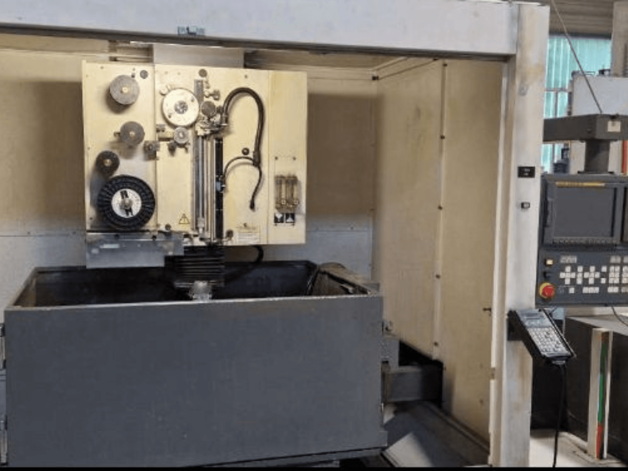 Máquina de electroerosión por hilo FANUC ROBOCUT α-1iA, vista frontal que muestra el panel de control, el depósito de trabajo y los componentes de la máquina.