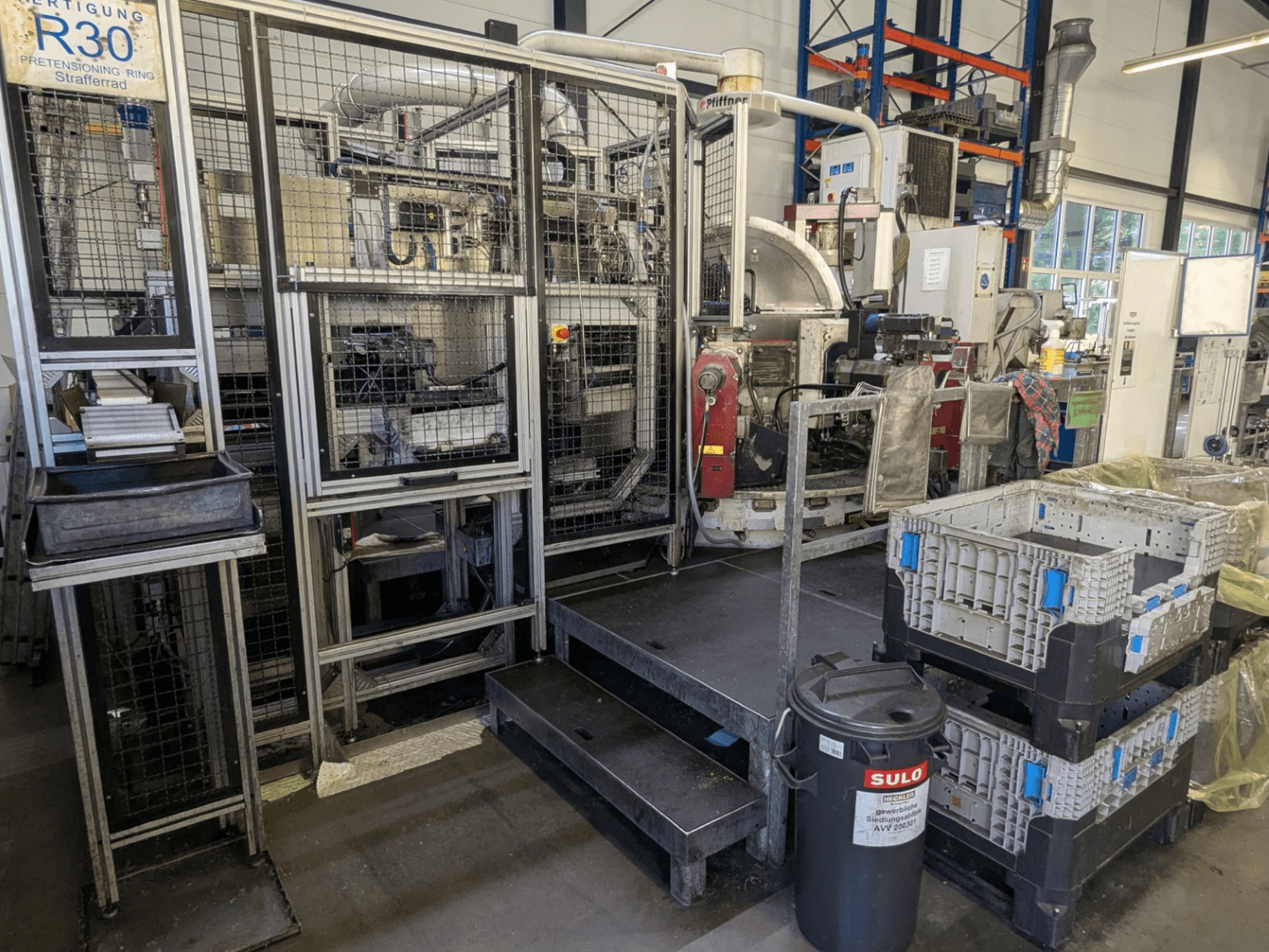 Máquina herramienta PFIFFNER HB 32/16 en un taller; vista frontal en la que se aprecia la zona de producción con contenedores y vallas de seguridad.