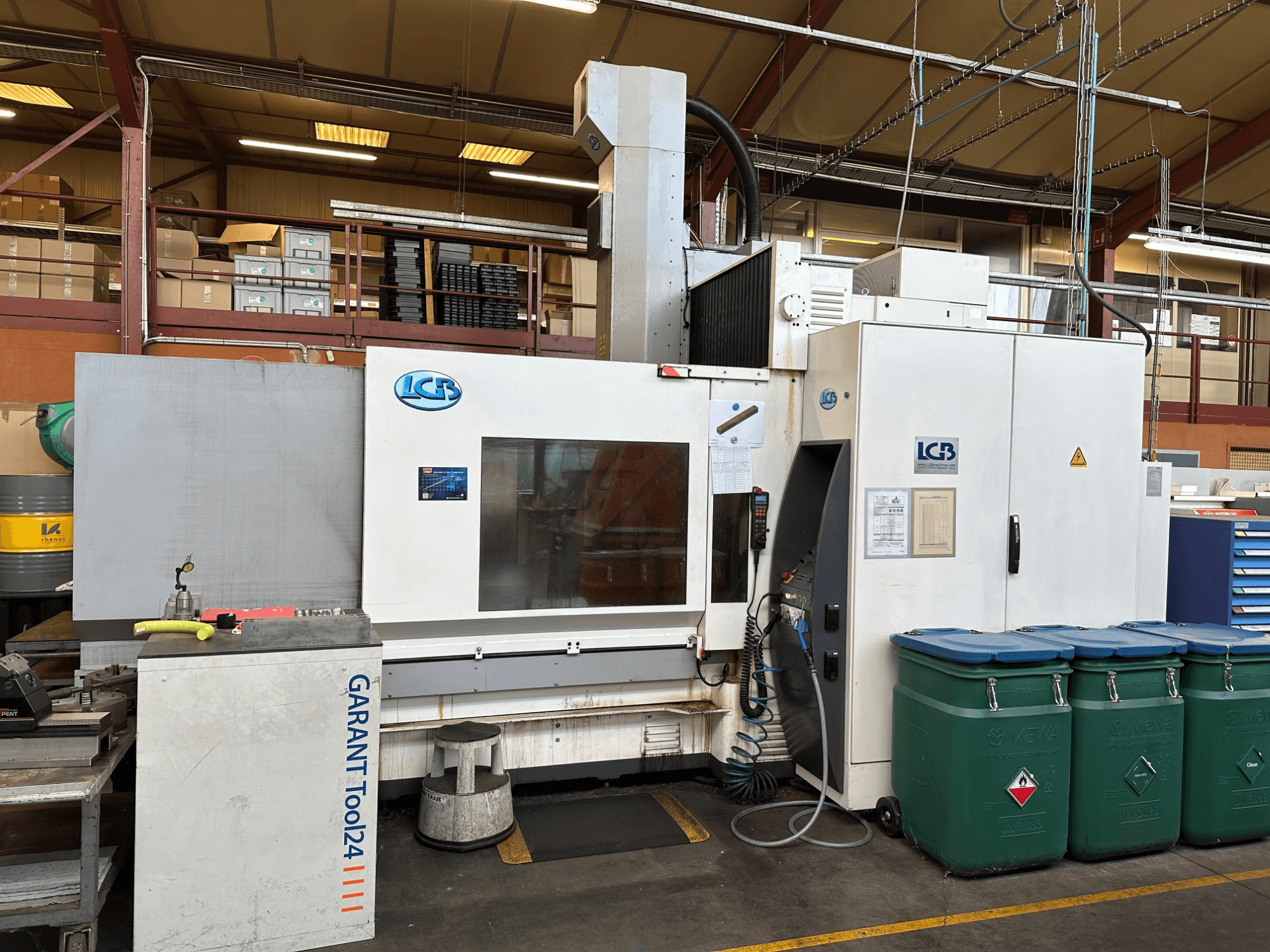 Máquina CNC LGB vista de frente, con estación de trabajo GARANT Tool24 y contenedores de residuos verdes en el lateral.