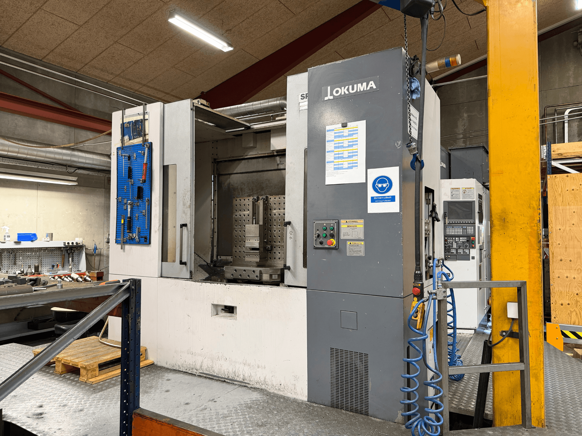 Centro de mecanizado horizontal Okuma MA-600HB en un taller; vista frontal en la que se aprecian el panel de control y la zona de trabajo.