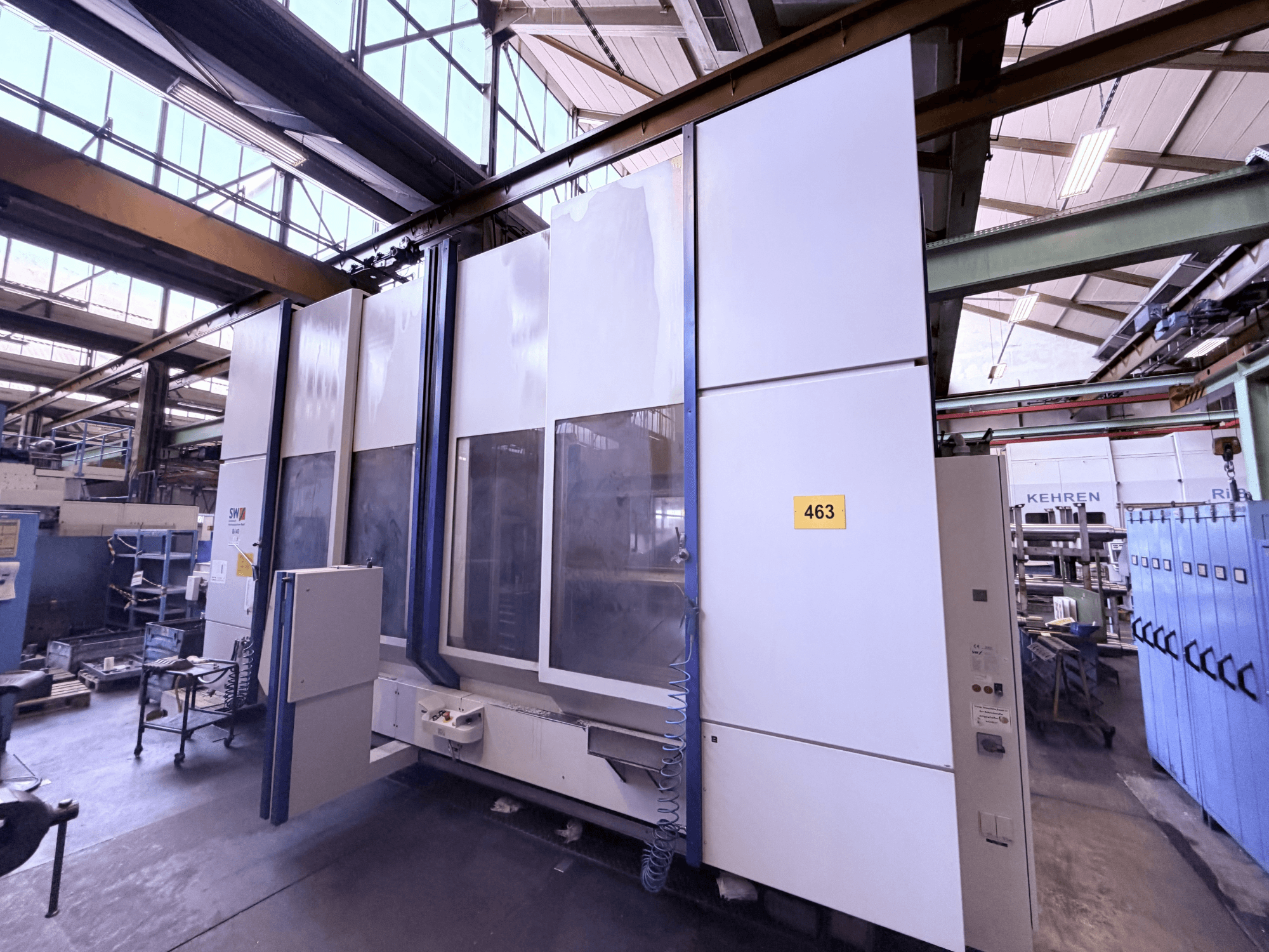 Centro de mecanizado vertical SW BA 40, vista lateral, en la que se aprecian el panel de control, la amplia zona de trabajo y el entorno industrial circundante.