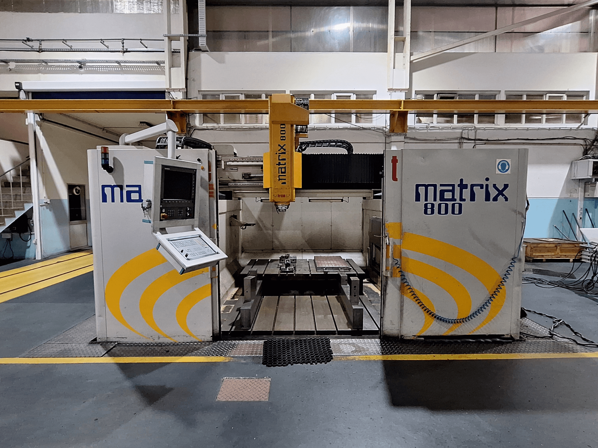 Fresadora de pórtico Breton Matrix WM 800 K25 en un taller, mostrando el panel de control y la mesa de trabajo desde la vista frontal.