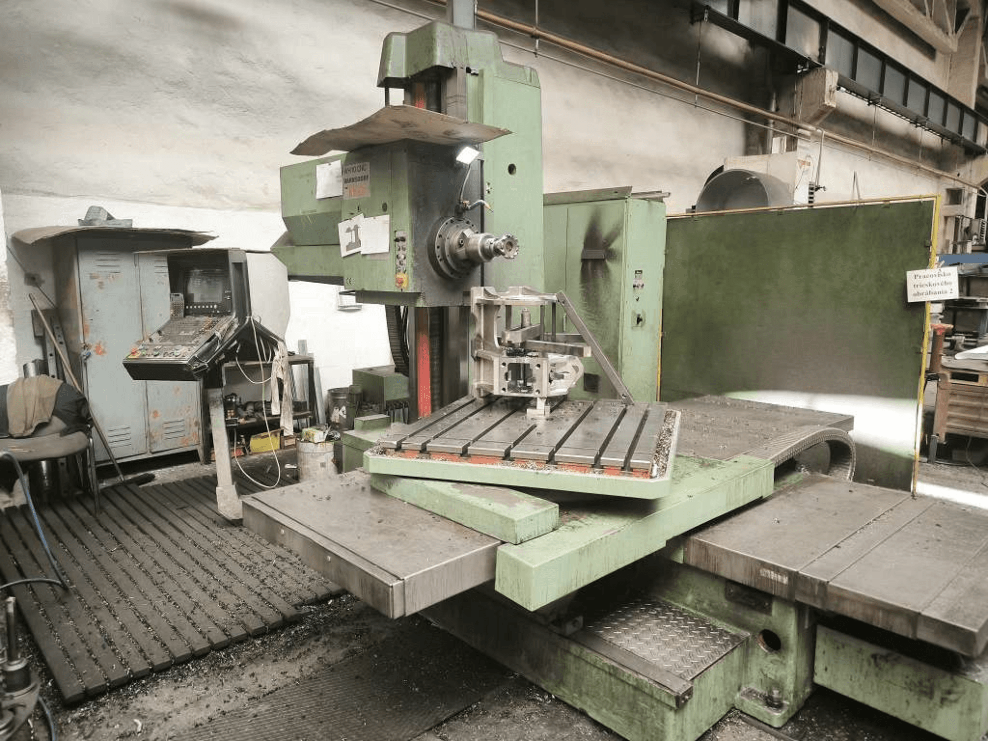 Máquina de mandrinado CNC TOS WH 10 vista desde delante, en la que se aprecia una pieza mecanizada sobre la mesa y el panel de control.