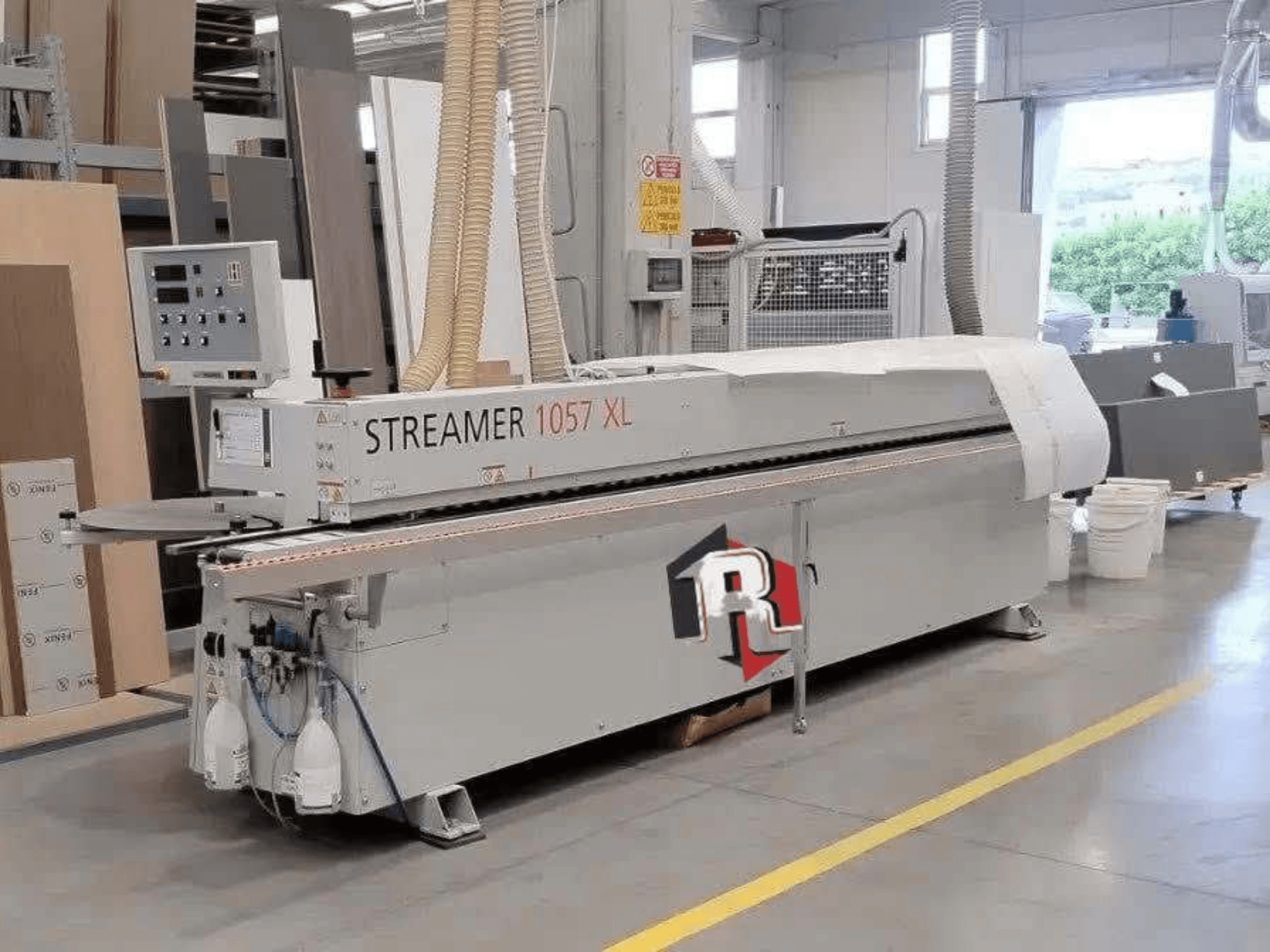 Cantadora HOLZHER STREAMER 1057 XL en un taller, vista lateral con el panel de control y las mangueras de aire a la vista.