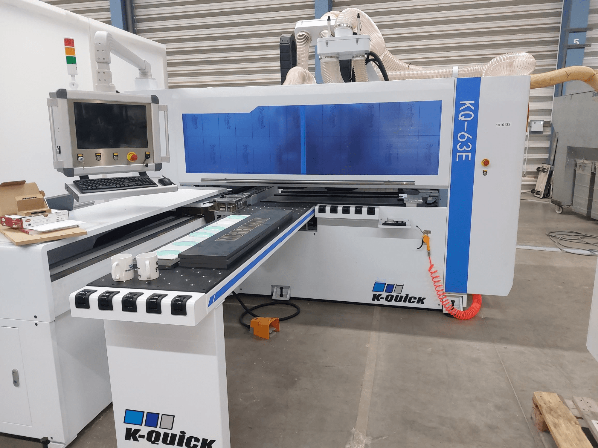 Máquina CNC K-Quick KQ-63E vista de frente, con panel de control, bancada plana y colocación visible de herramientas.