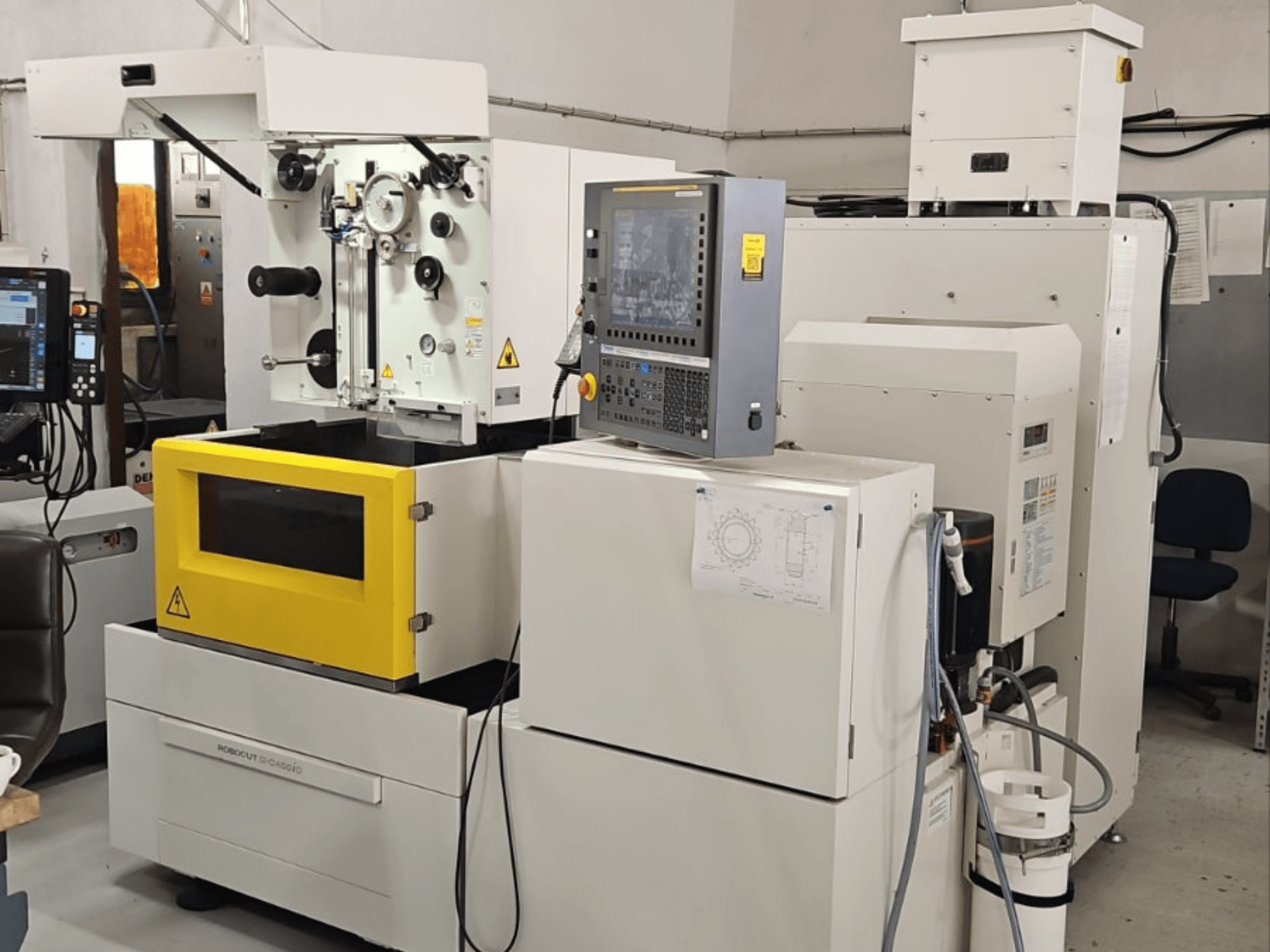 Máquina de electroerosión por hilo FANUC Robocut alpha C400iC, vista frontal en la que se aprecian el panel de control y la cámara de trabajo amarilla.