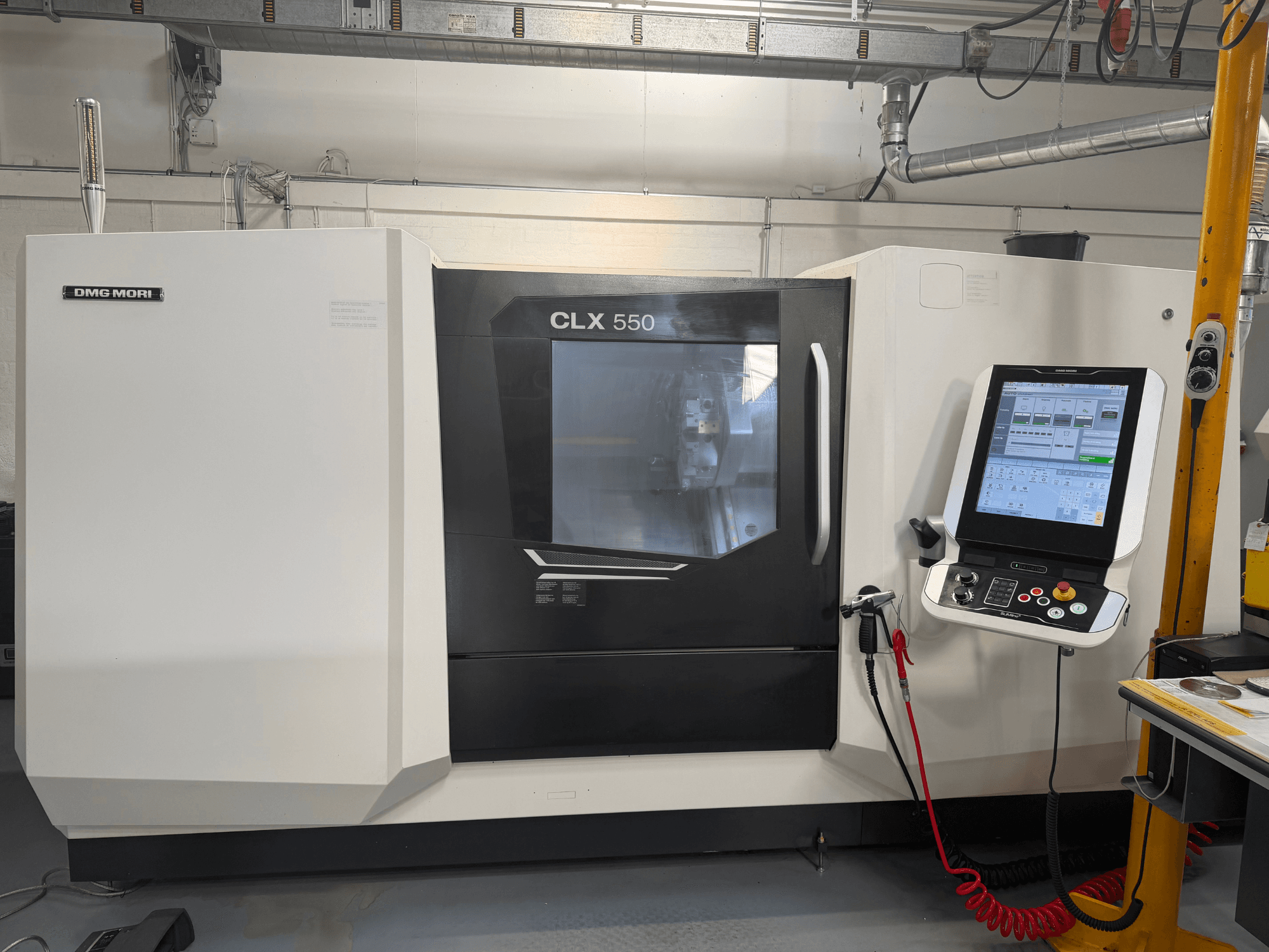 Torno horizontal DMG MORI CLX 550 V4, vista frontal con panel de control y pantalla, en la que se muestran sus avanzadas funciones de mecanizado.