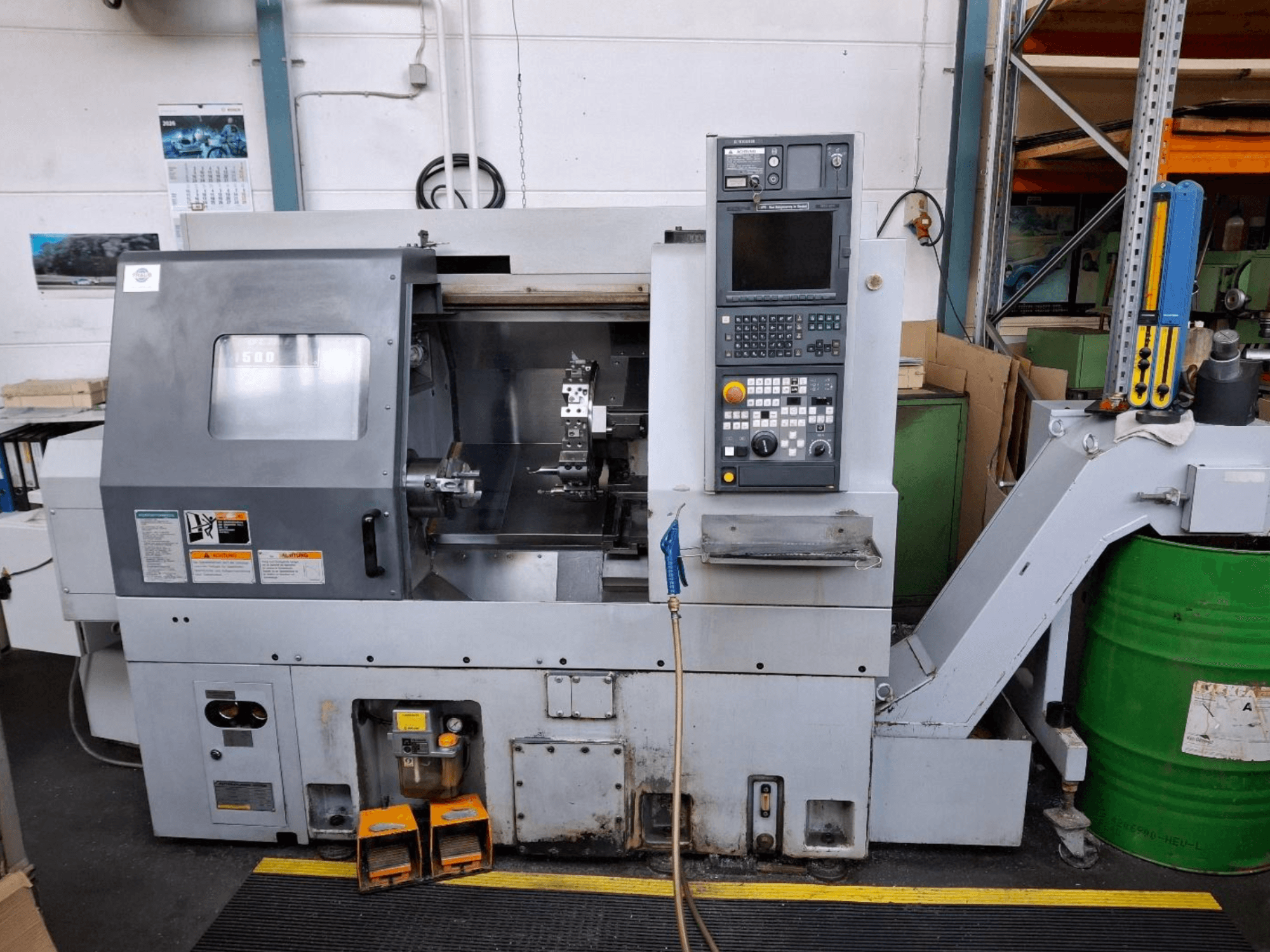 Máquina de torneado horizontal MORI SEIKI CL 1500 T, vista frontal con panel de control, herramientas visibles y pantalla operativa.
