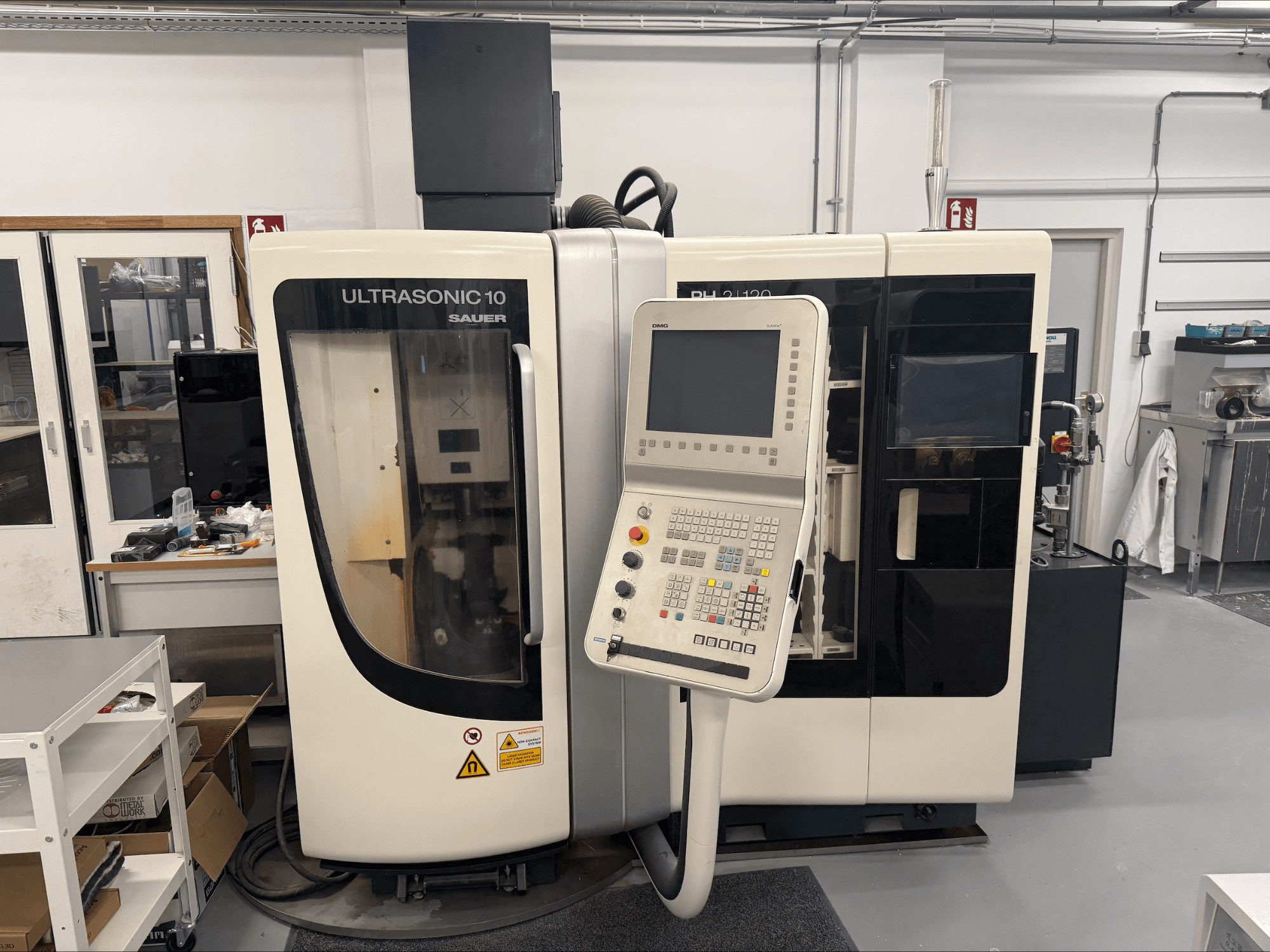 Centro de mecanizado vertical DMG Sauer Ultrasonic 10 + PH 2 | 120, vista frontal, con panel de control y gran ventana de visualización.