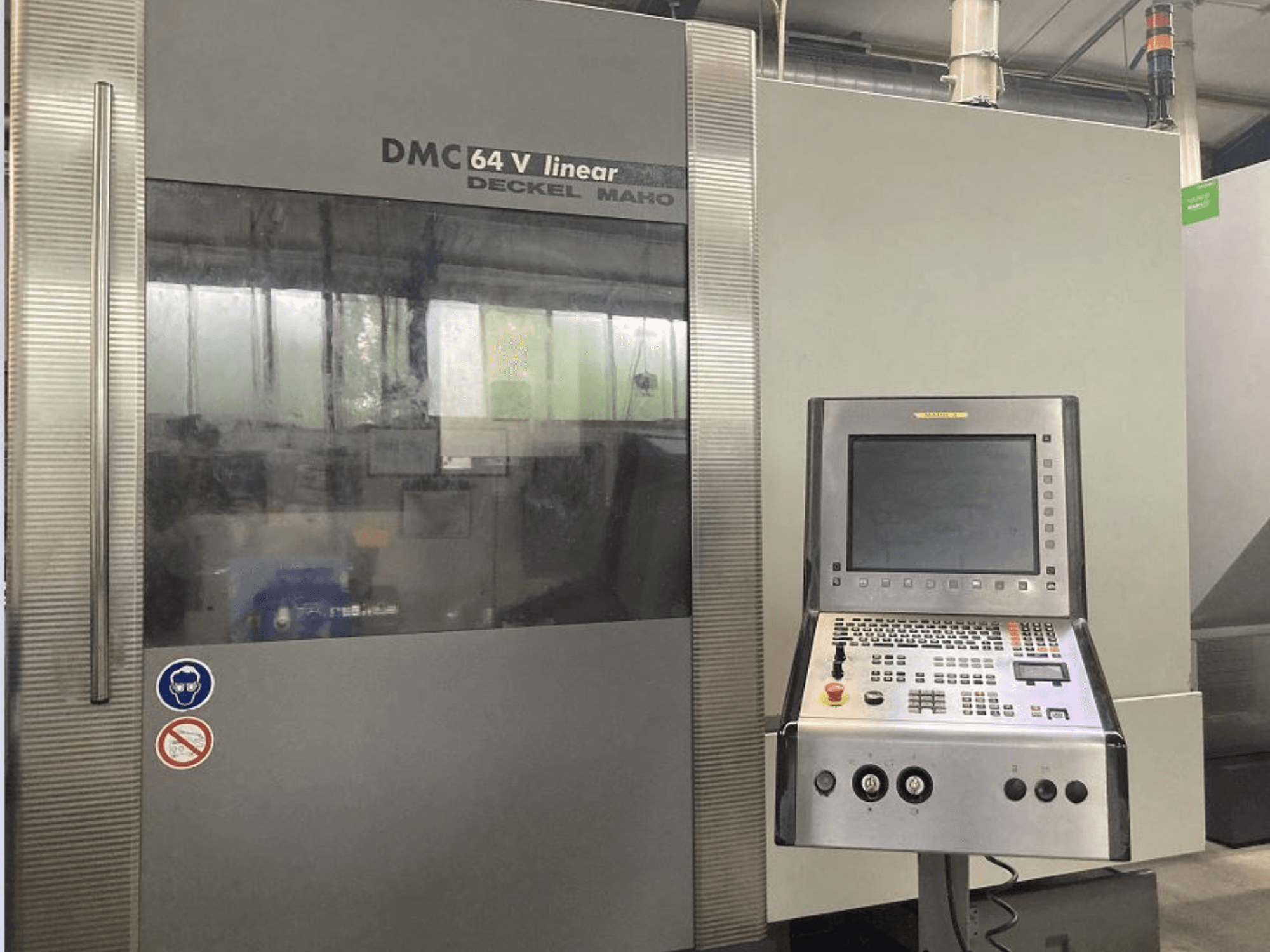 Centro de mecanizado vertical lineal DMG DECKEL MAHO DMC 64V, vista frontal con panel de control y pantalla.