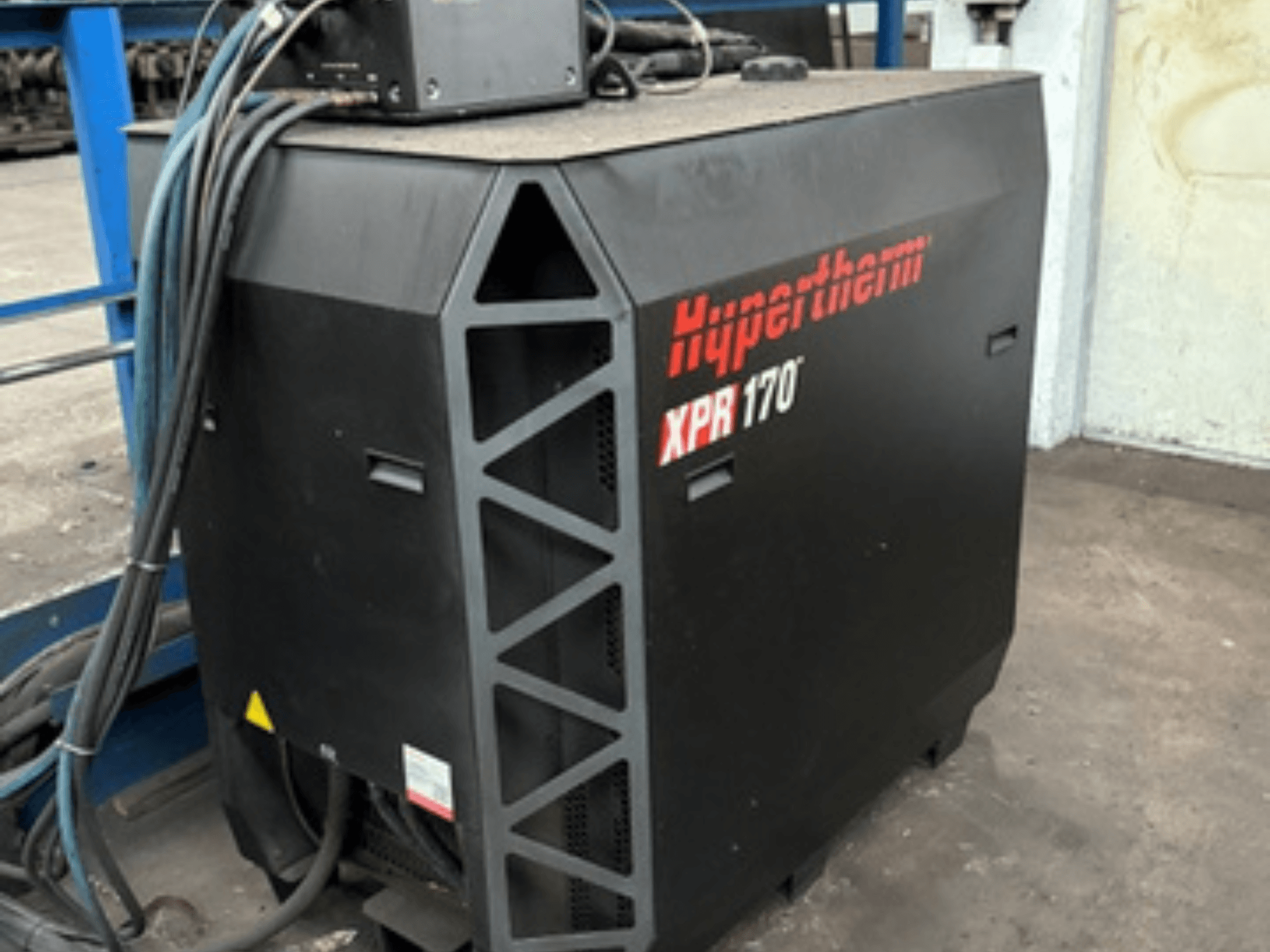 Cortadora por plasma Hypertherm XPR170, vista de lado, con rejillas de refrigeración y múltiples cables para su funcionamiento.