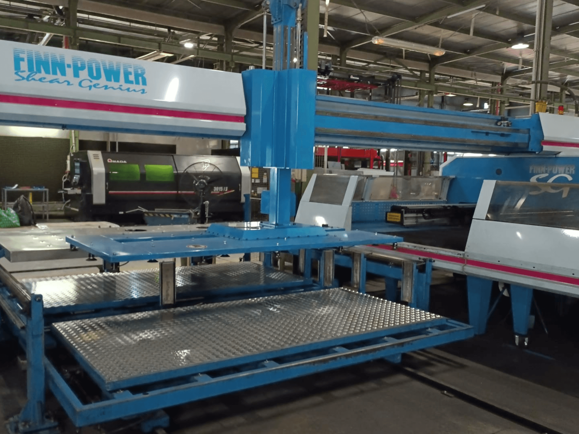 Máquina punzonadora CNC «Shear Genius» SG6 de Finn-Power, vista frontal, en la que se aprecian las mesas metálicas y las características estructurales.