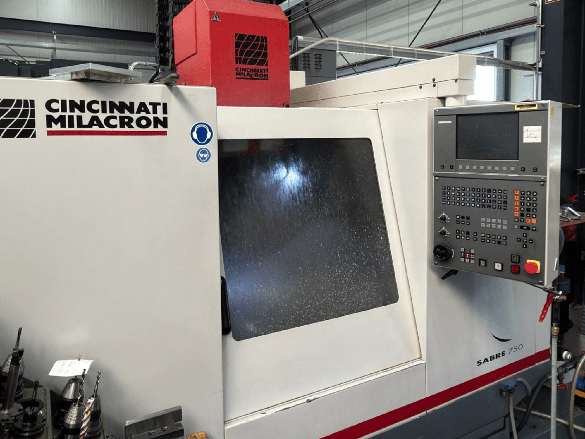 Centro de mecanizado vertical Cincinnati Milacron Sabre 750, vista frontal, con panel de control y cristal parcialmente oculto.