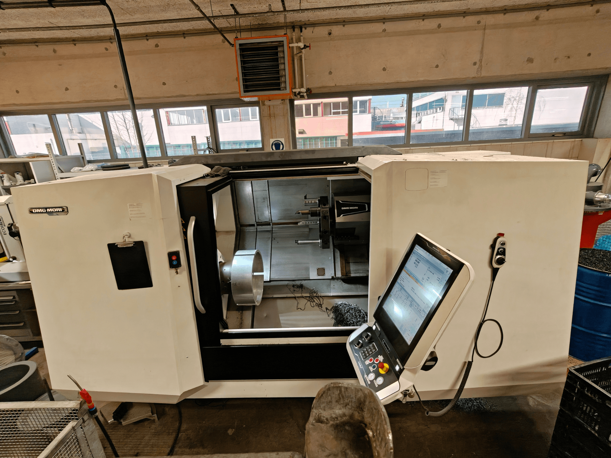 Vista frontal de un torno horizontal DMG MORI CLX 550, mostrando el panel de control y la zona de trabajo abierta.