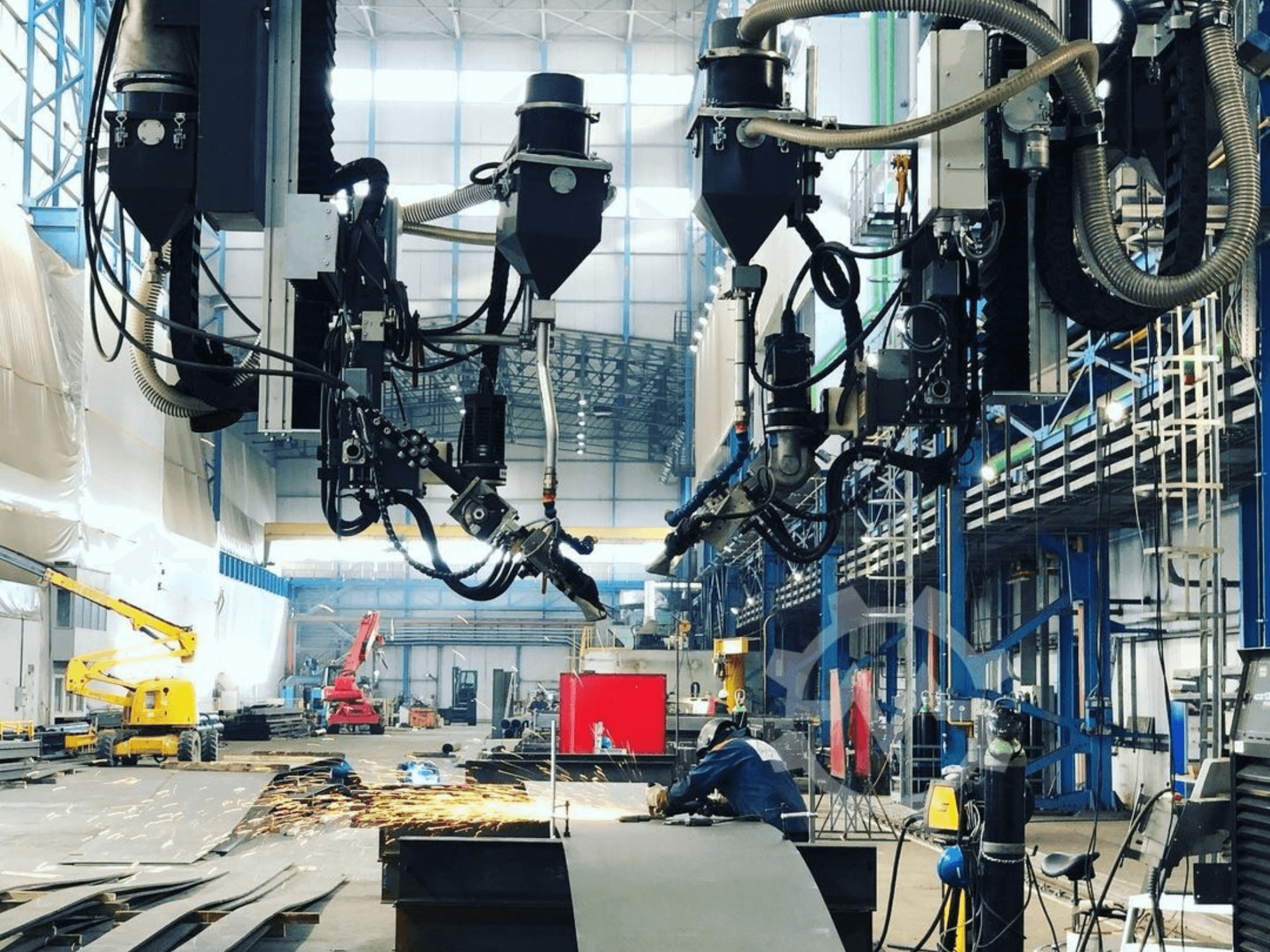 Máquina de corte robotizada en un entorno industrial, con chispas saltando, vista desde el lateral; cuenta con múltiples accesorios y mangueras.