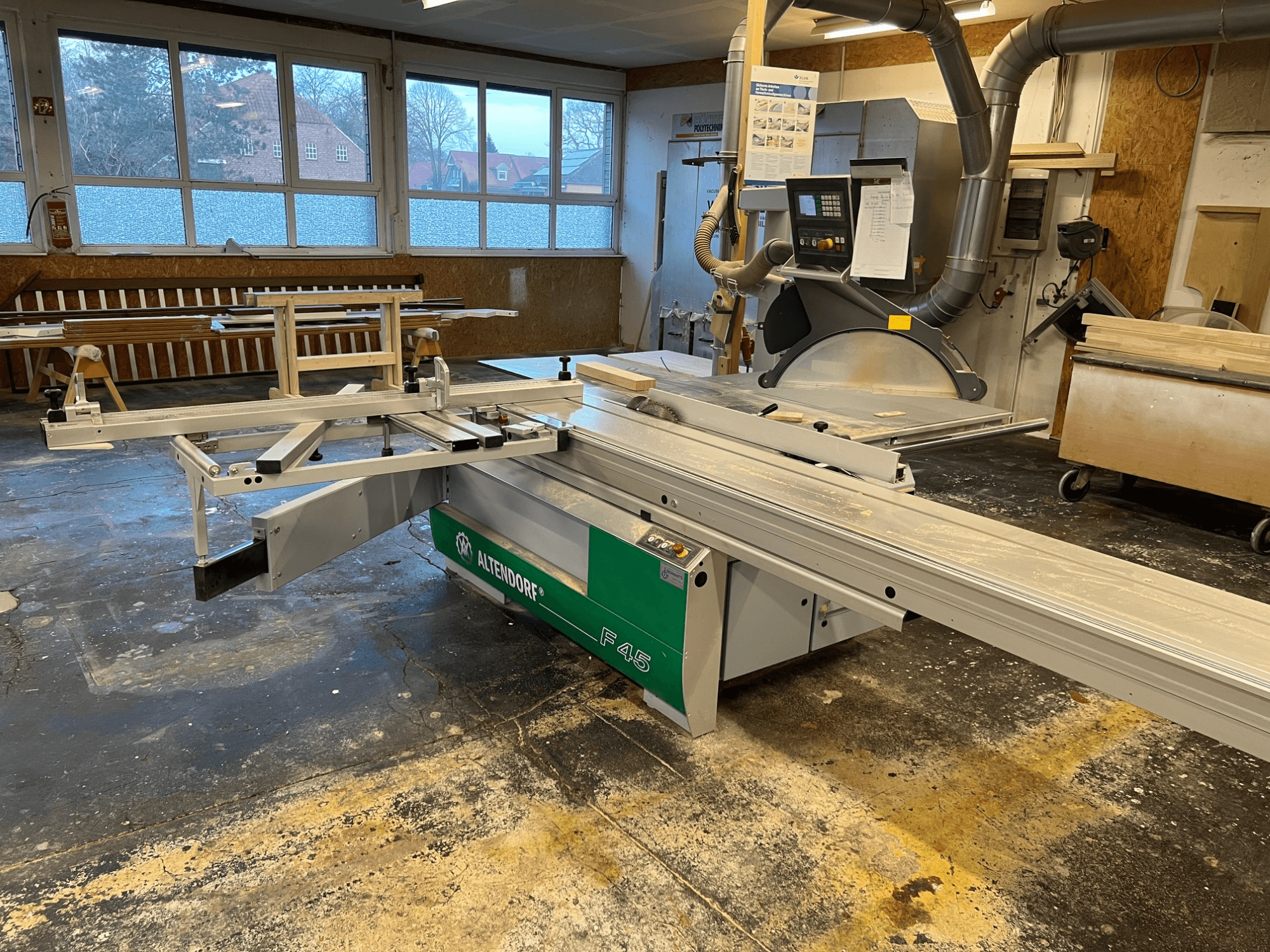 Sierra de mesa Altendorf F45 en un taller, vista frontal mostrando el brazo ajustable y el panel de control, ideal para tareas de corte de precisión.