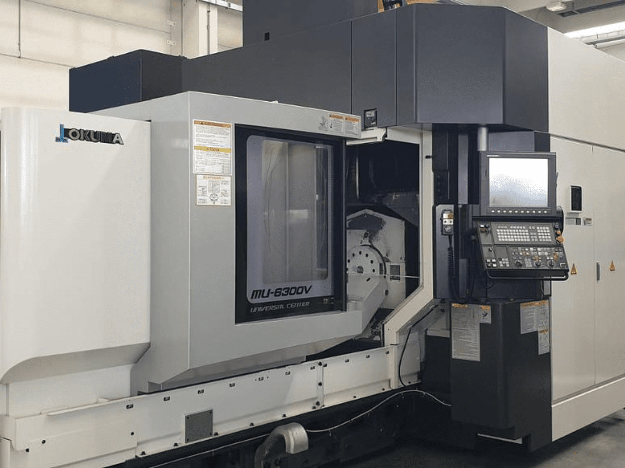 Centro de mecanizado vertical Okuma MU 6300 V, vista frontal con panel de control y detalles del área de mecanizado.