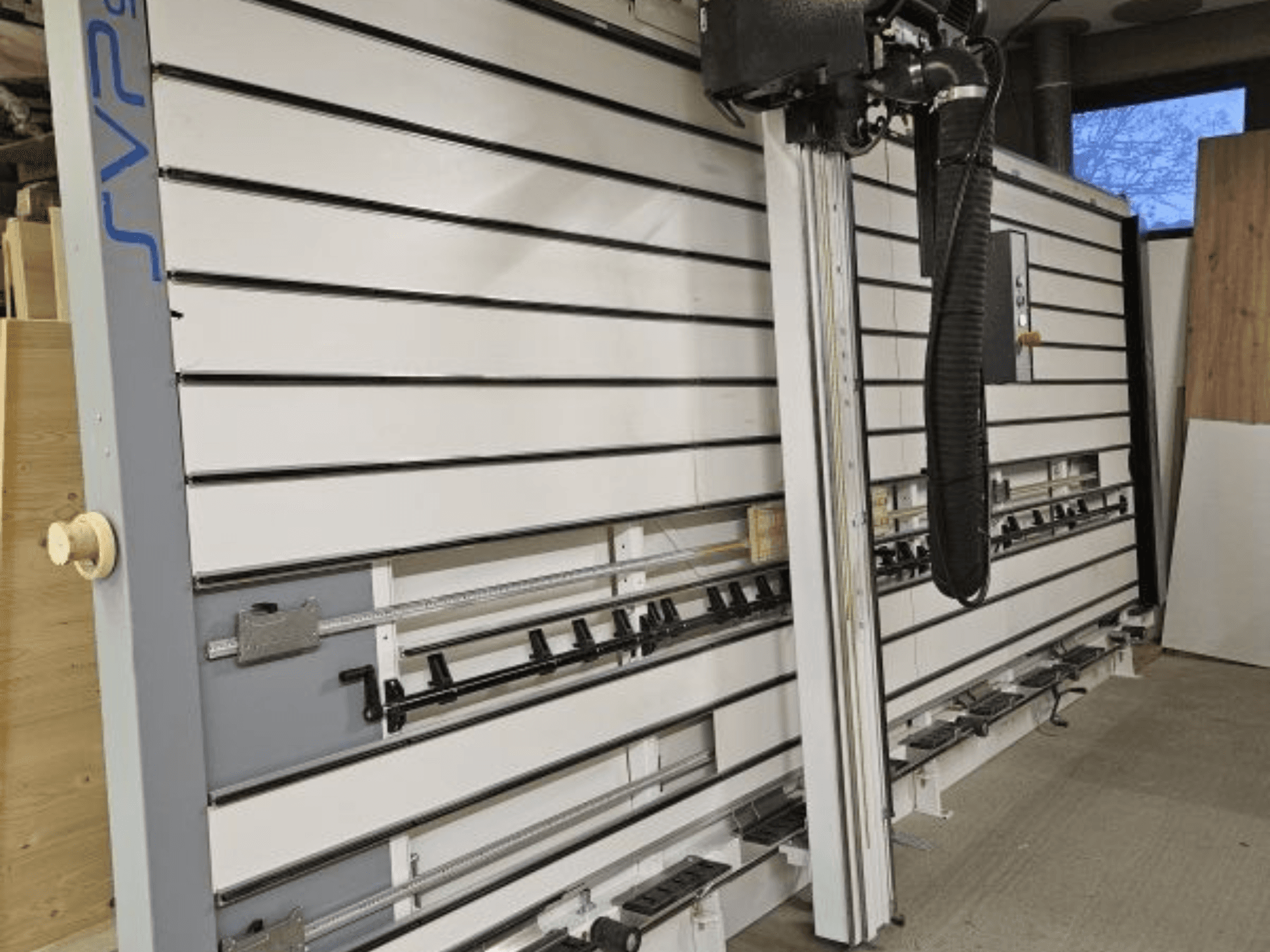 Seccionadora SVP en un taller, vista frontal, con guías ajustables y sistema de aspiración superior.