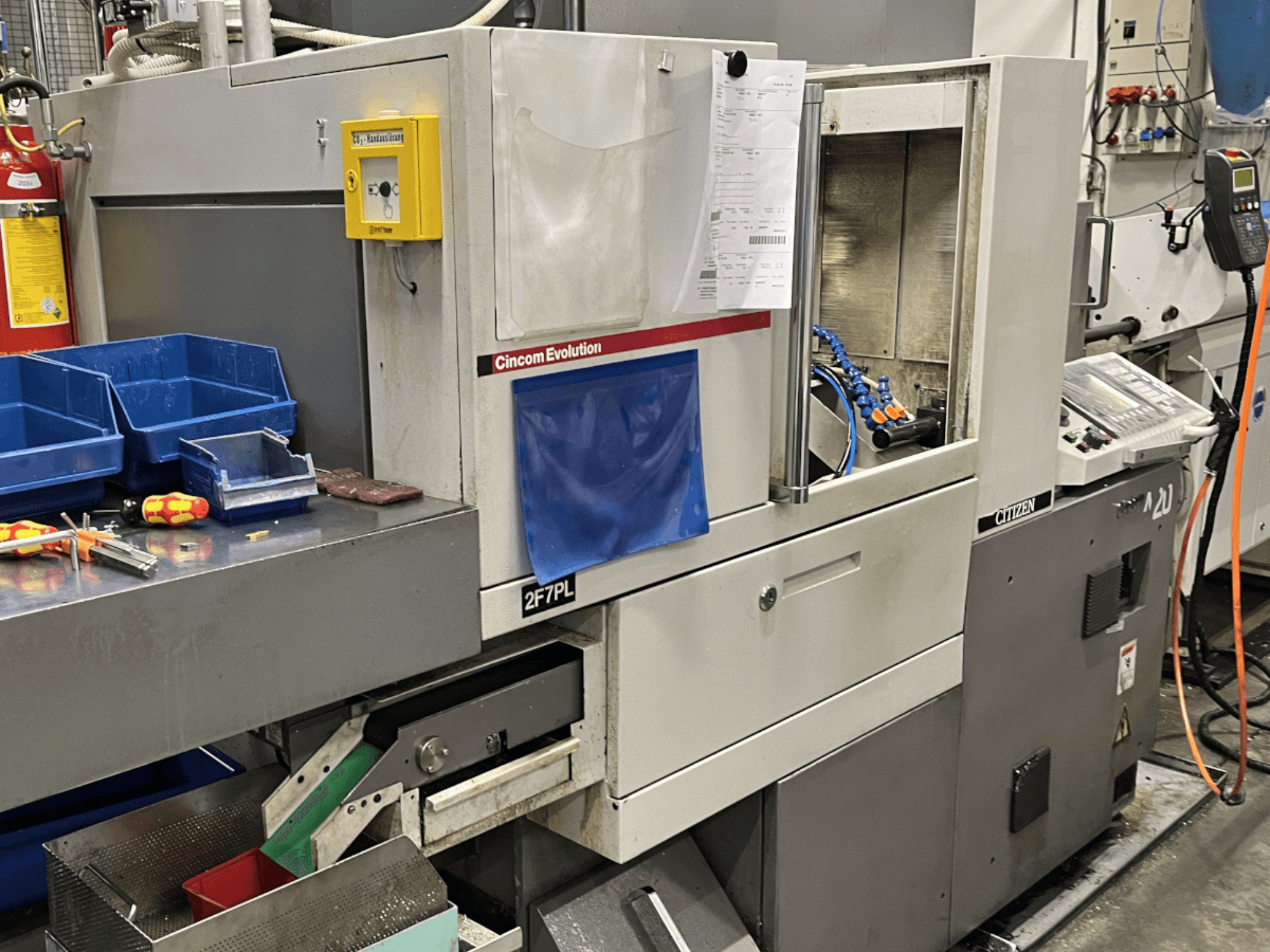 Centro de mecanizado Cincom Evolution 2F7PL, vista frontal; incluye controles, compartimentos para herramientas y un panel de control detallado.