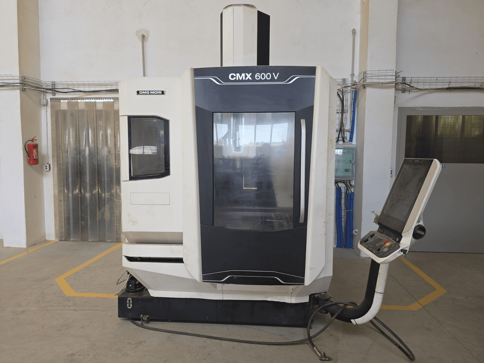 Centro de mecanizado vertical DMG MORI CMX 600 V, vista frontal, mostrando el panel de control y la gran ventana transparente.