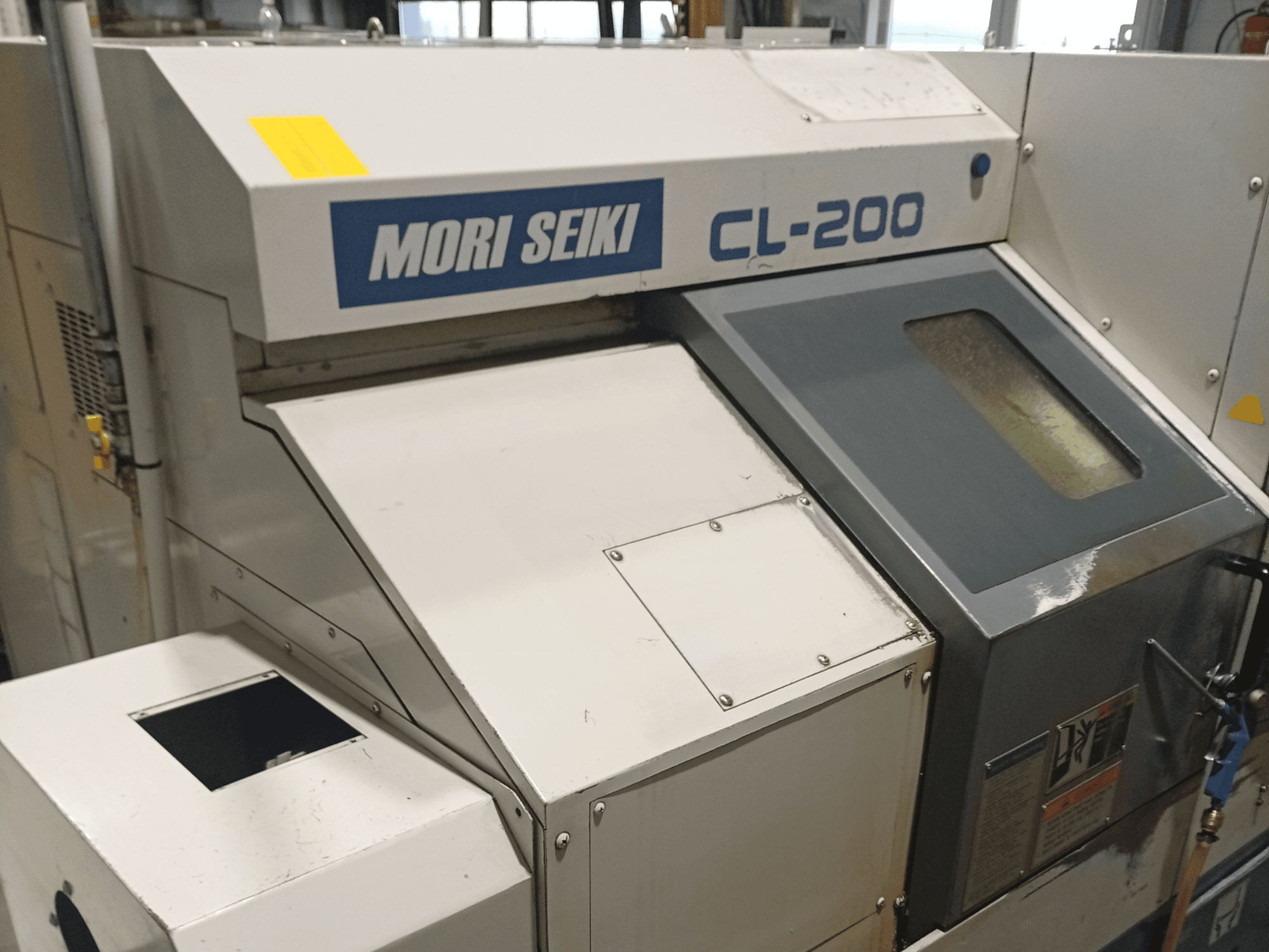 DMG Mori Seiki CL-200B máquina de torneado horizontal, vista frontal mostrando el panel de control y los detalles de la ventana de refrigerante.