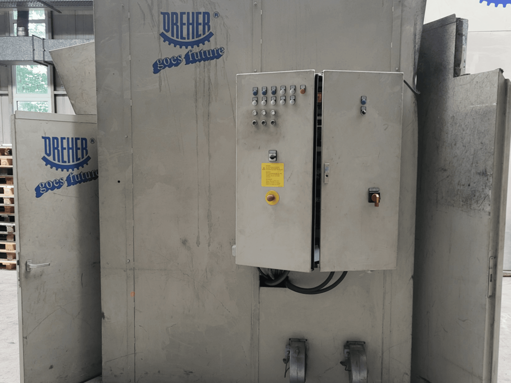 Máquina de procesamiento de plástico DREHER S 42/65 GFS-15 GR, vista frontal en la que se aprecian el panel de control y el logotipo de la marca, en un entorno industrial.