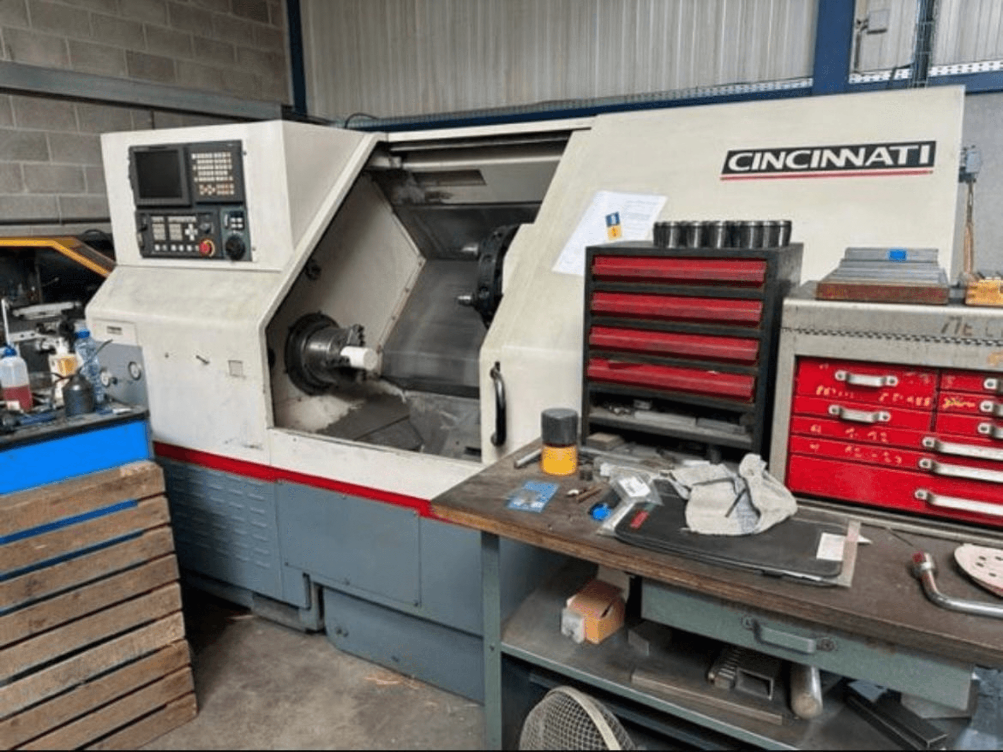Torno horizontal Cincinnati HAWK 200, vista lateral en la que se aprecian el panel de control, la zona de trabajo y el espacio de almacenamiento de herramientas situado cerca.
