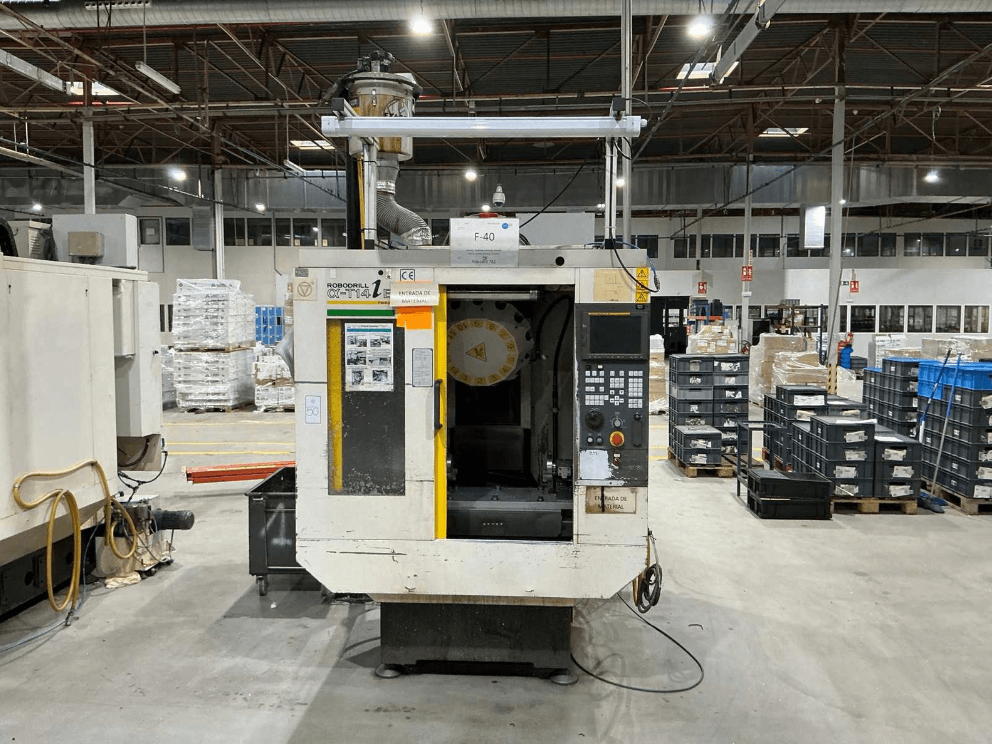 Centro de mecanizado vertical FANUC ROBODRILL α-T14iB en una fábrica, vista frontal mostrando el panel de control y el portaherramientas.