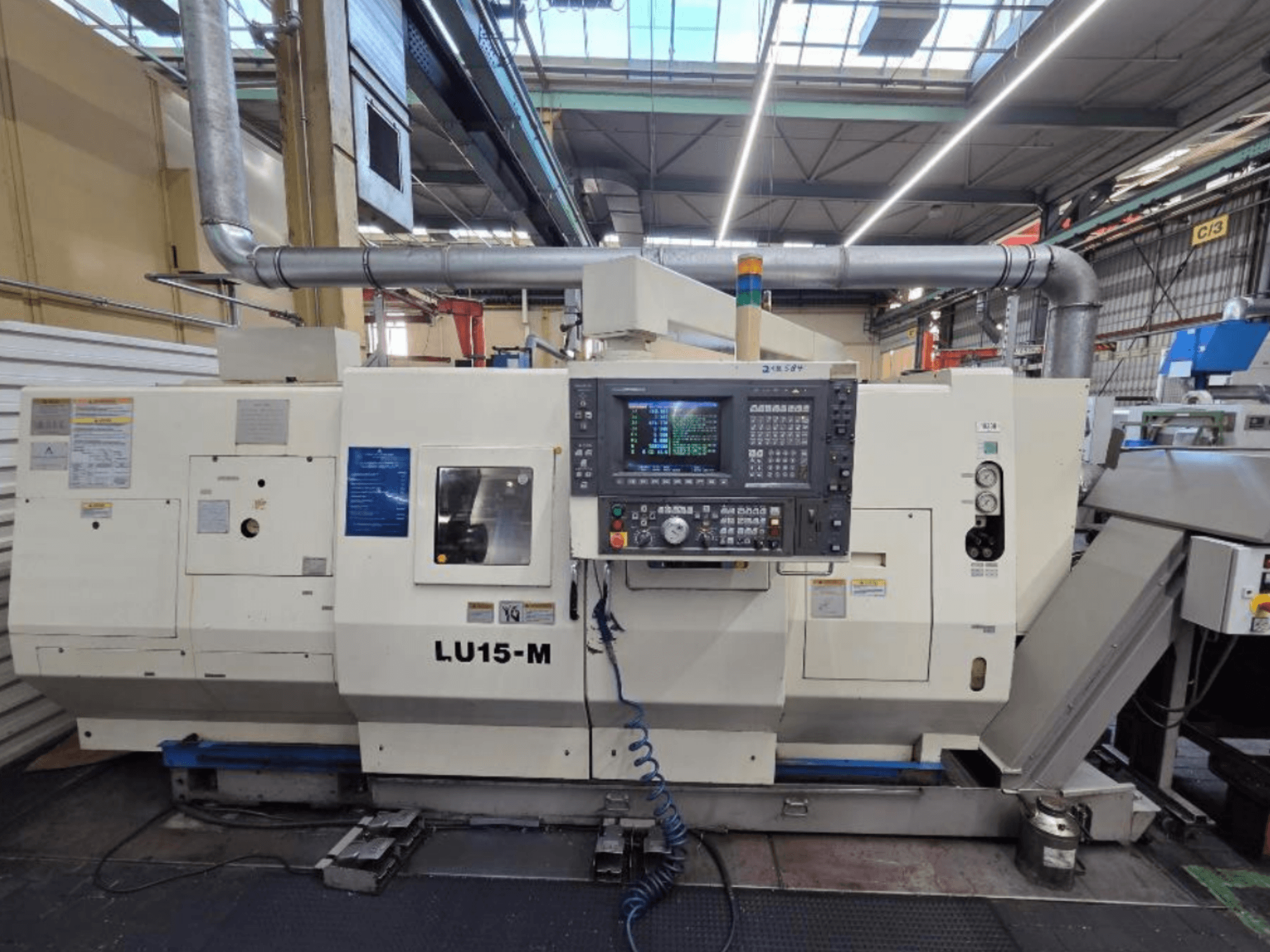 Máquina de torneado horizontal Okuma LU15 M-2SC 1000, vista frontal mostrando el panel de control y las características de la máquina en un entorno de taller.