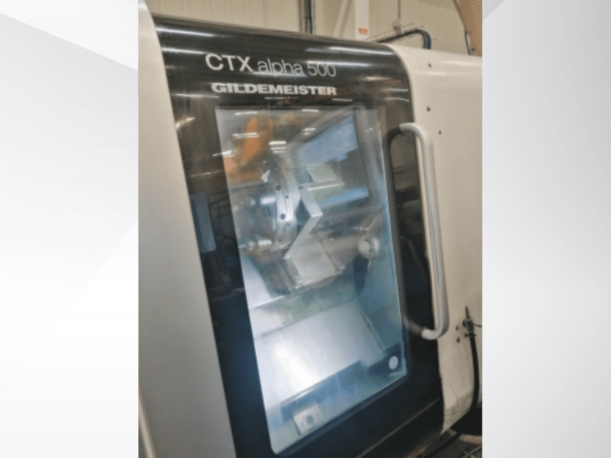 Máquina CNC CTX alpha 500 Gildemeister, vista frontal, mostrando el husillo y la zona de mecanizado a través de la puerta de cristal.