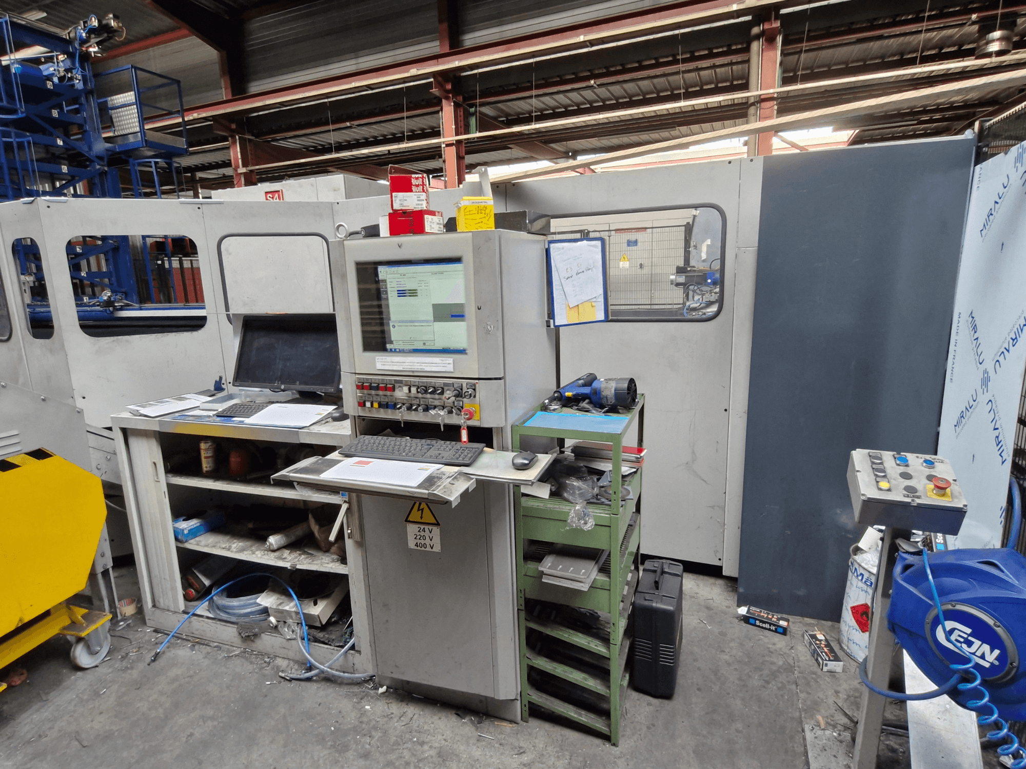 Punzonadora CNC Salvagnini S4-40 en un taller, con panel de control con monitores y herramientas, vista frontal.