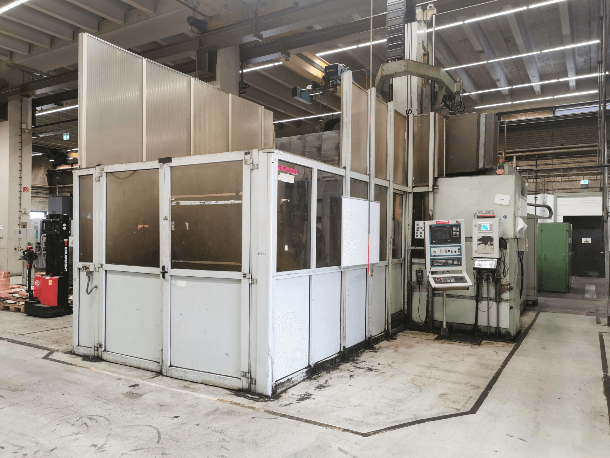 Fresadora de pórtico JOBS Jomach 241, vista frontal, en la que se aprecian los mandos de la máquina y la cabina de seguridad en un entorno industrial.