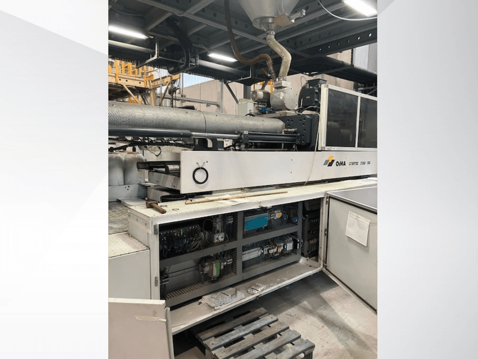 Vista frontal de la OMA Extruder 3500, mostrando las partes operativas, el panel de control y los detalles del cableado. Maquinaria pesada en un entorno industrial.